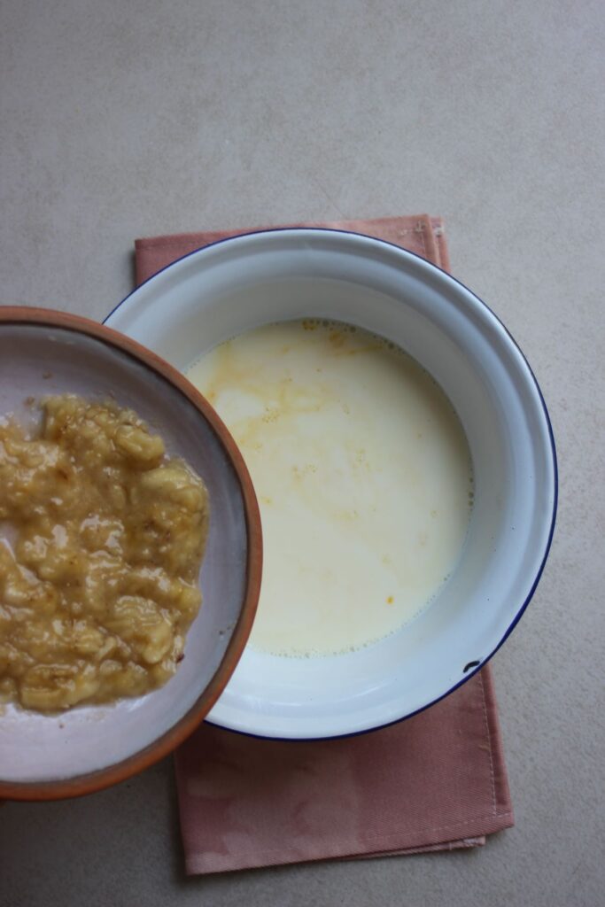 A plate with mashed bananas is about to be poured into a bowl with liquid.