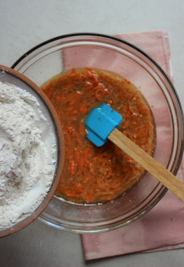 A plate with flour to be poured into a glass bowl with a liquid mixture.