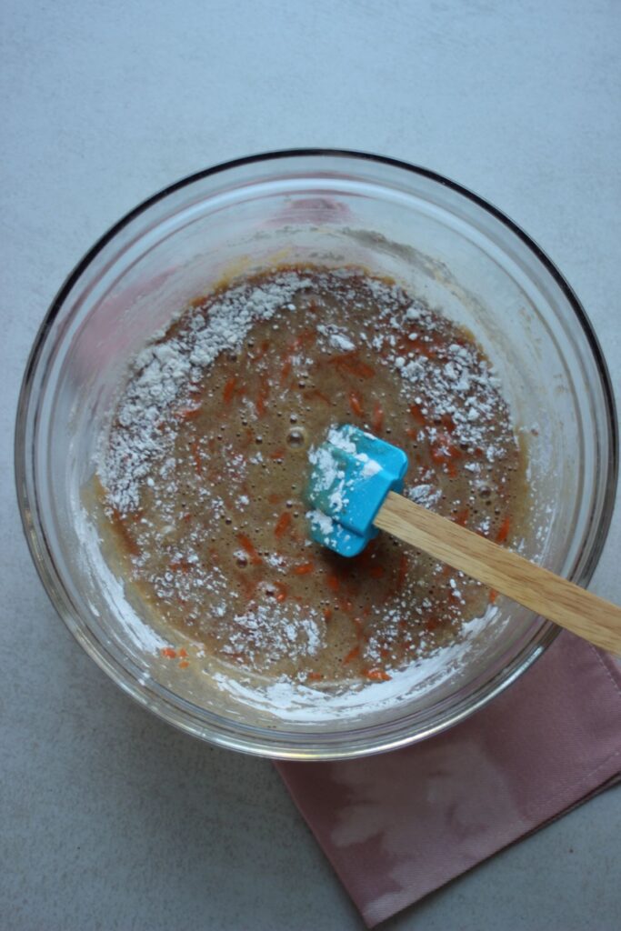 Glass bowl with a mixture and some flour.