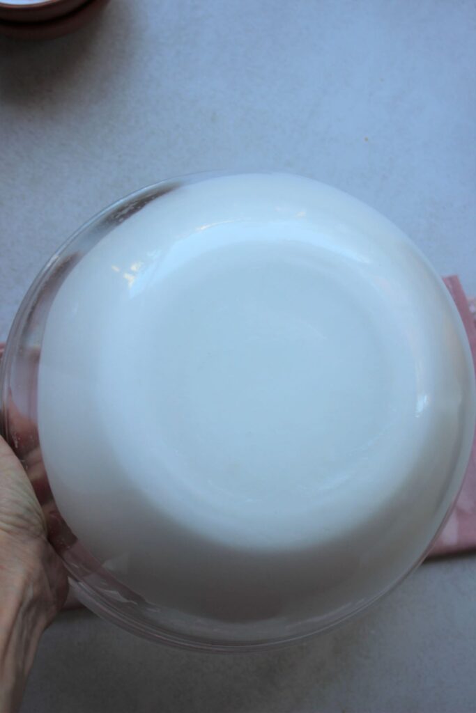 A glass bowl with meringue turned upside down.