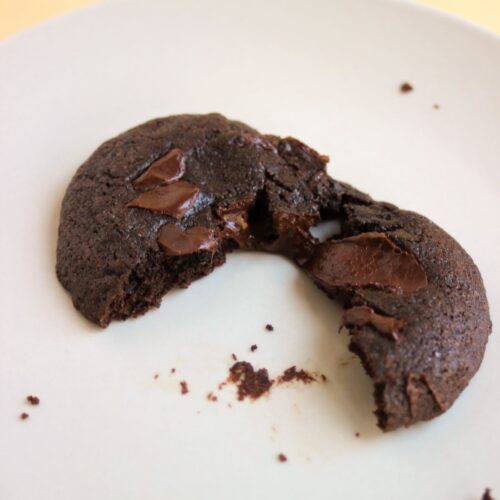 Chocolate cookie cut in two on a white plate.