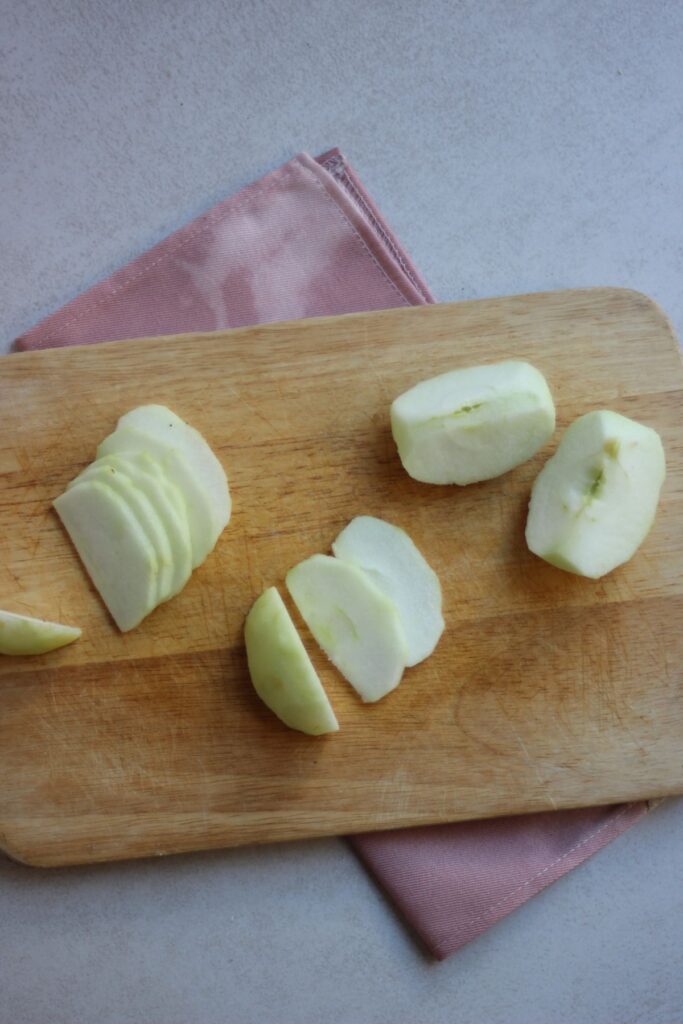 Slices of apple on a wooden board.