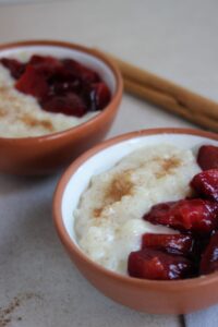 Two tiny bowls with rice pudding and plum compote.