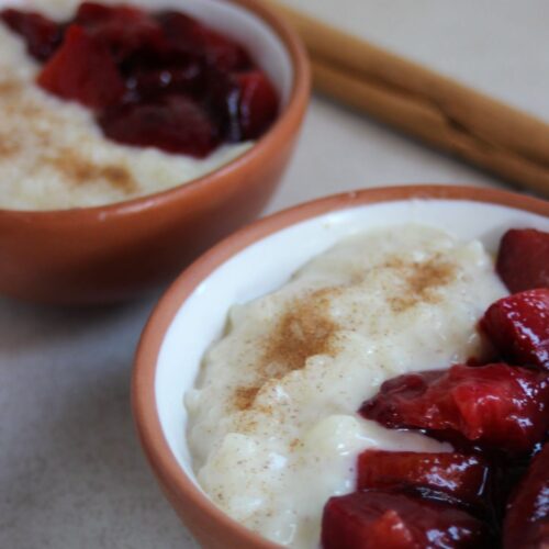 Two tiny bowls with rice pudding and plum compote.