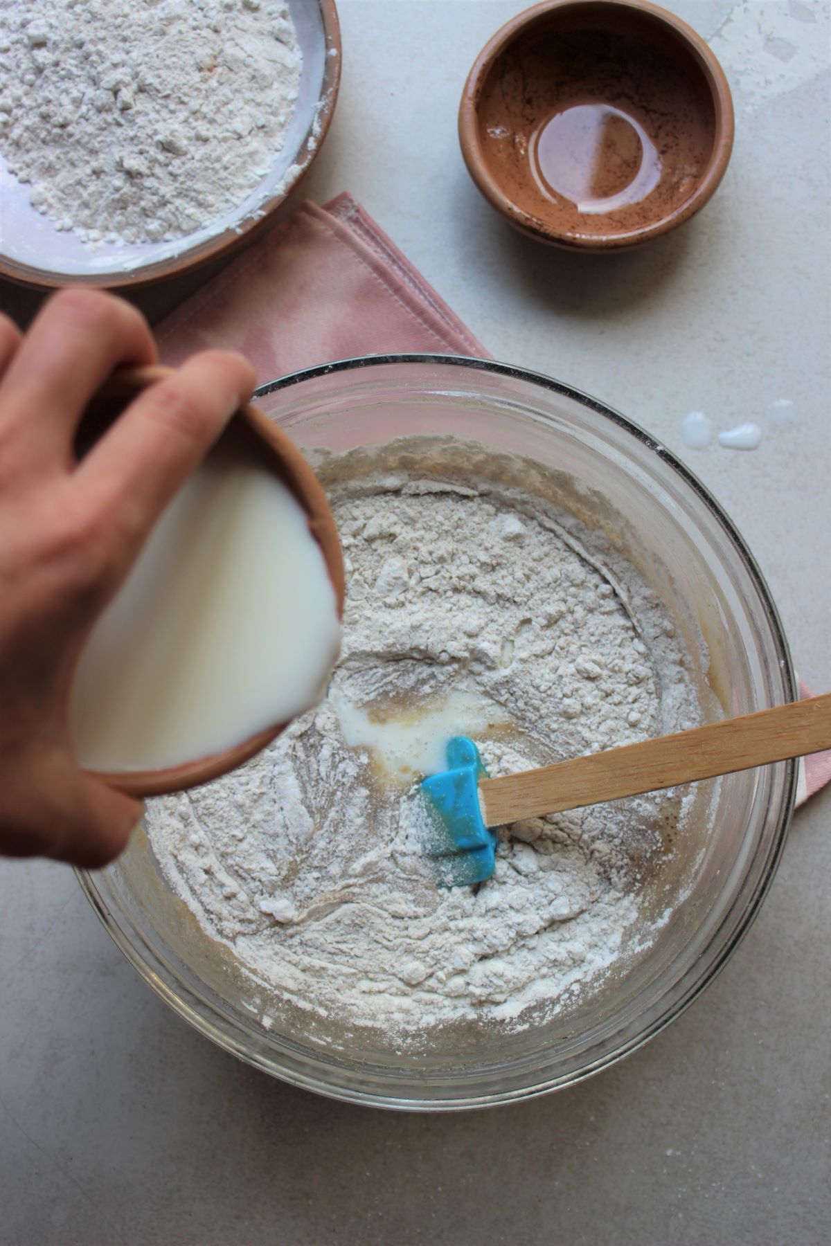 Banana loaf process: glass bowl with the loaf mixture, dry ingredients and adding the milk.