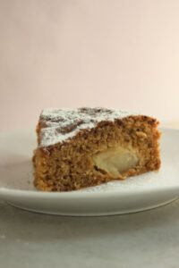 A portion of apple cake on a white plate.