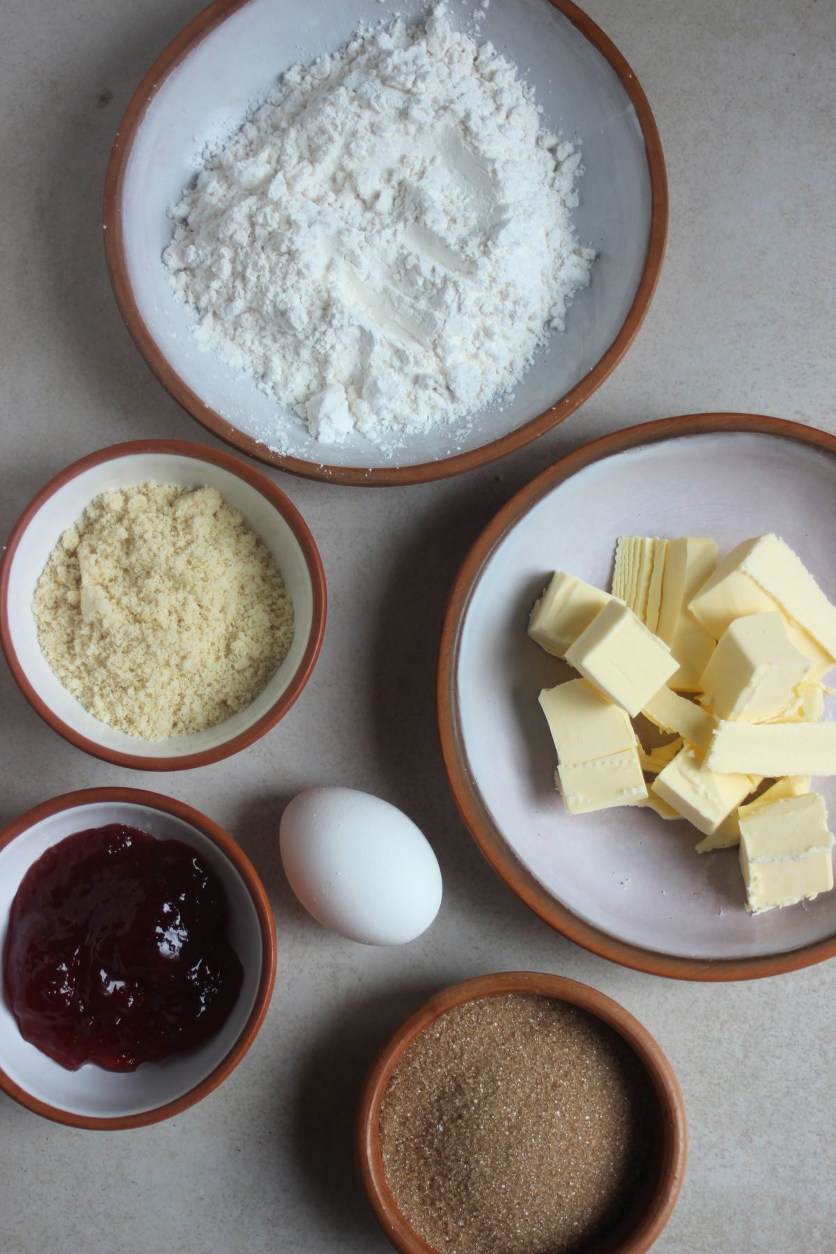 Almond thumbprint cookies ingredients on a white surface seen from above.