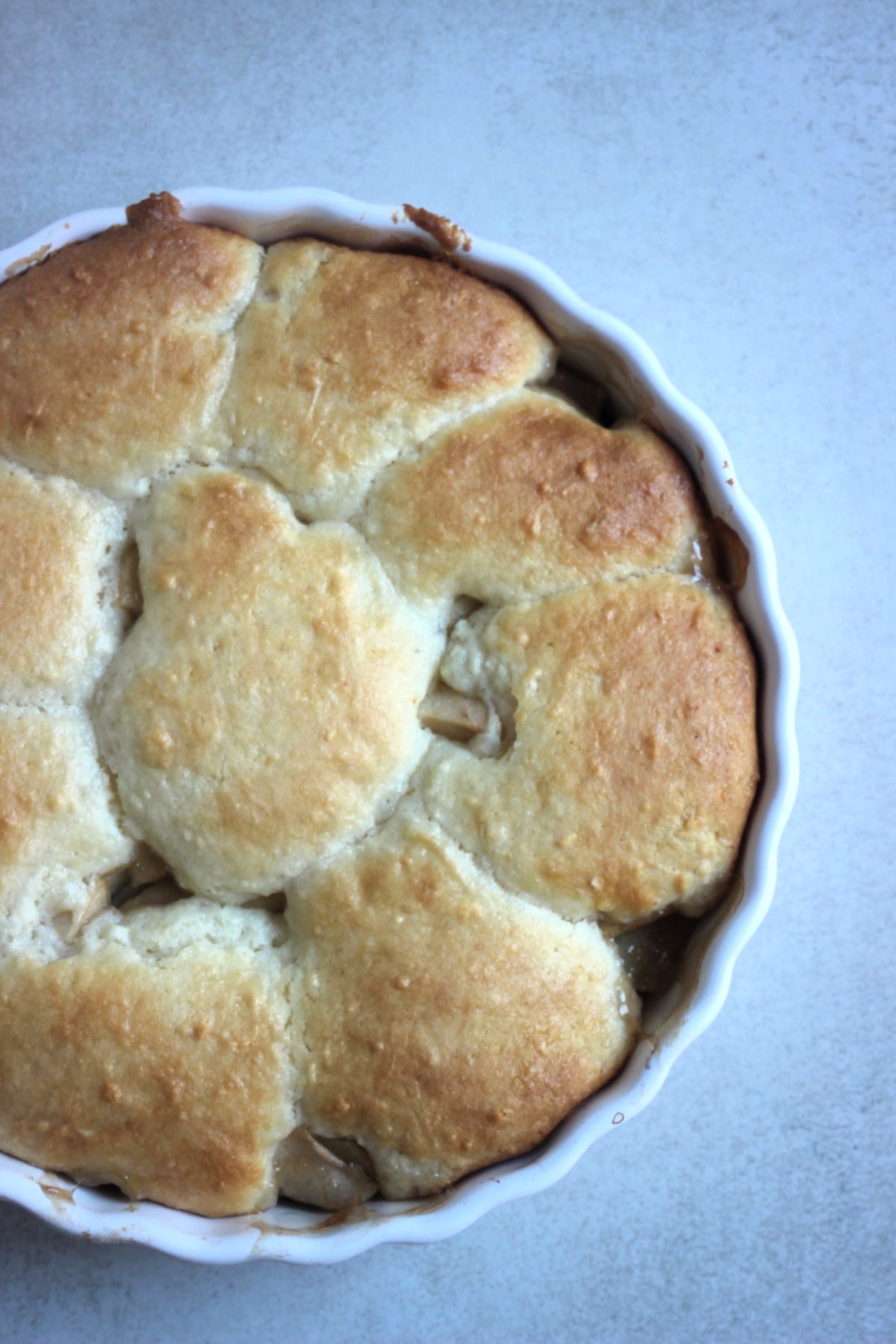 Apple cobbler on a round baking pan seen from above.