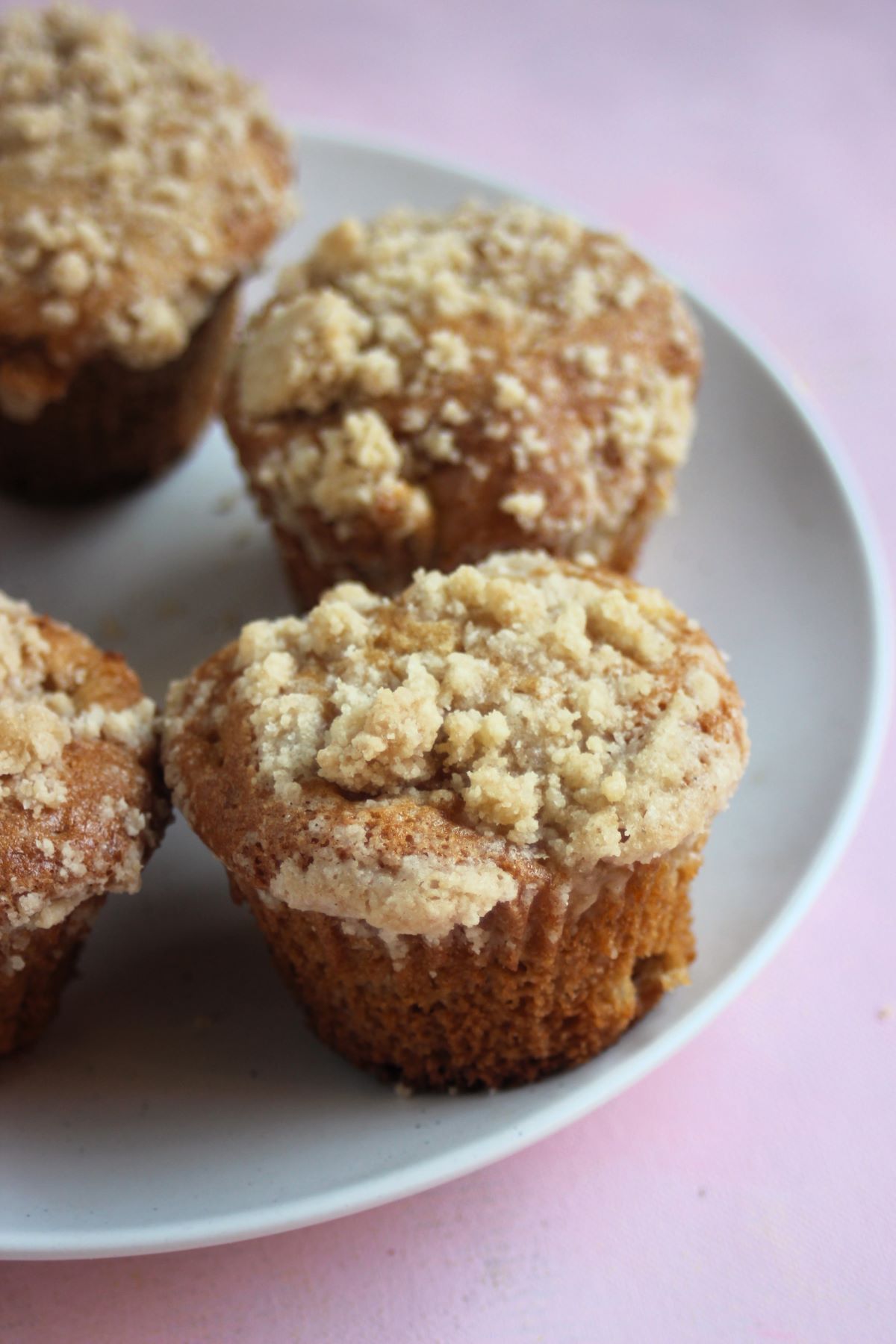 Apple crumb muffins on a white plate.