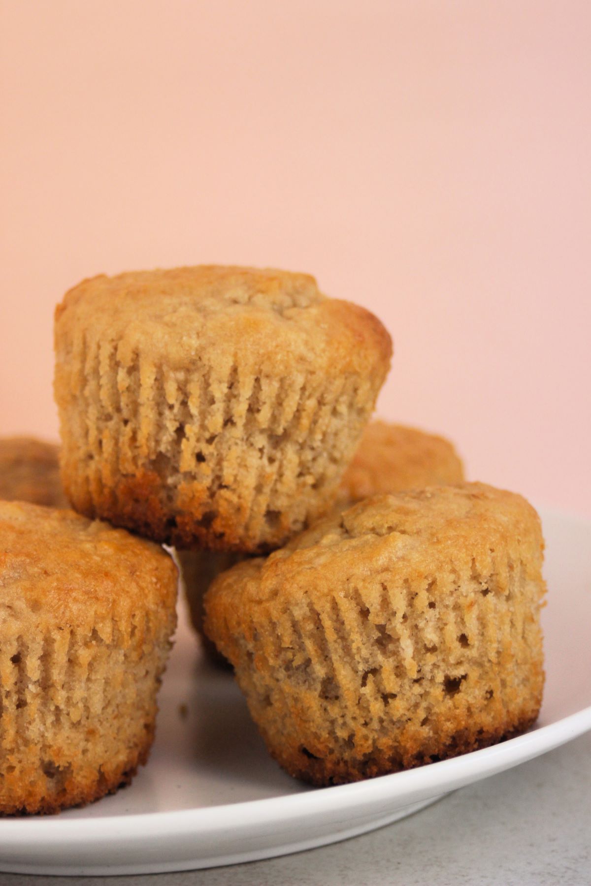 Oatmeal muffins on a white plate. Pink background.