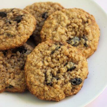 Oatmeal raisin cookies on a white plate.