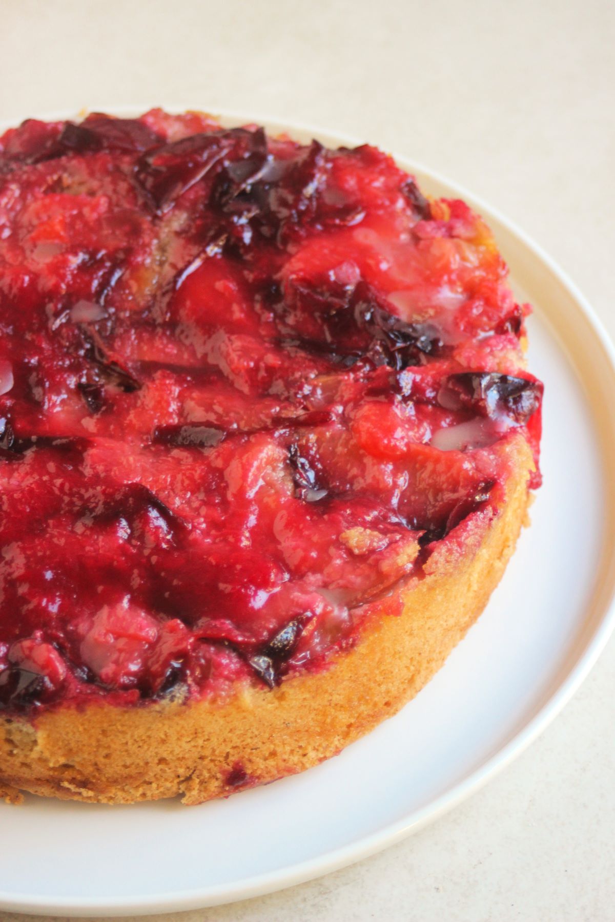 Plum upside down cake on white plate.