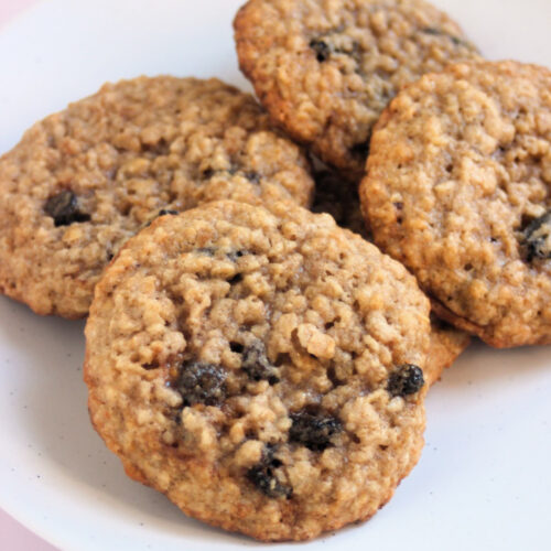 Oatmeal raisin cookies on a white plate.