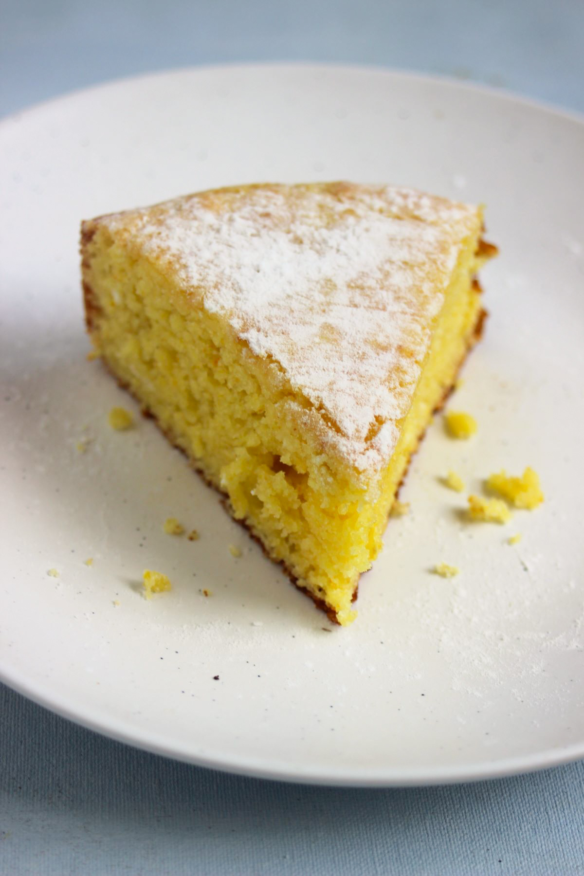 A portion of orange cake on white plate.