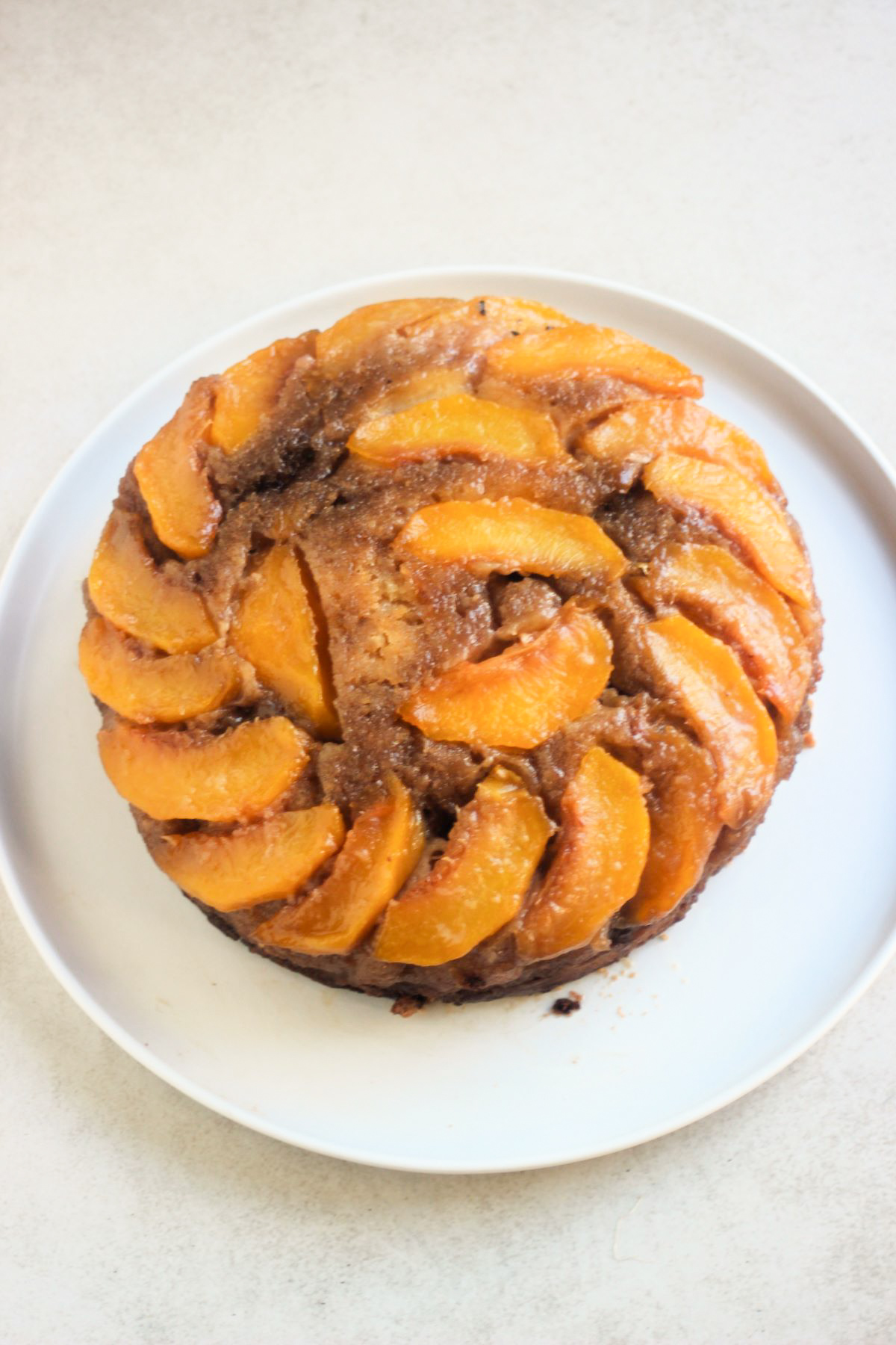 Peach upside down cake o a white plate.