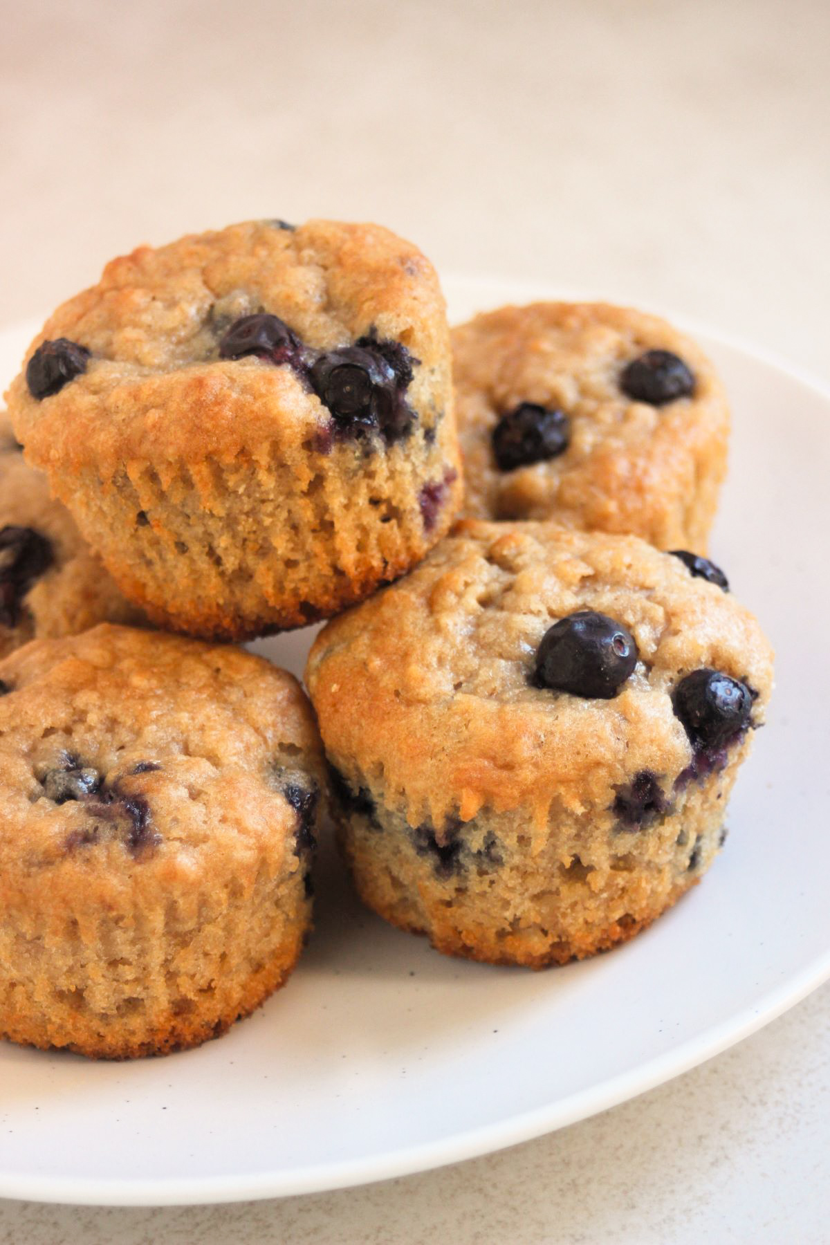 Oatmeal blueberry muffins on a white plate.