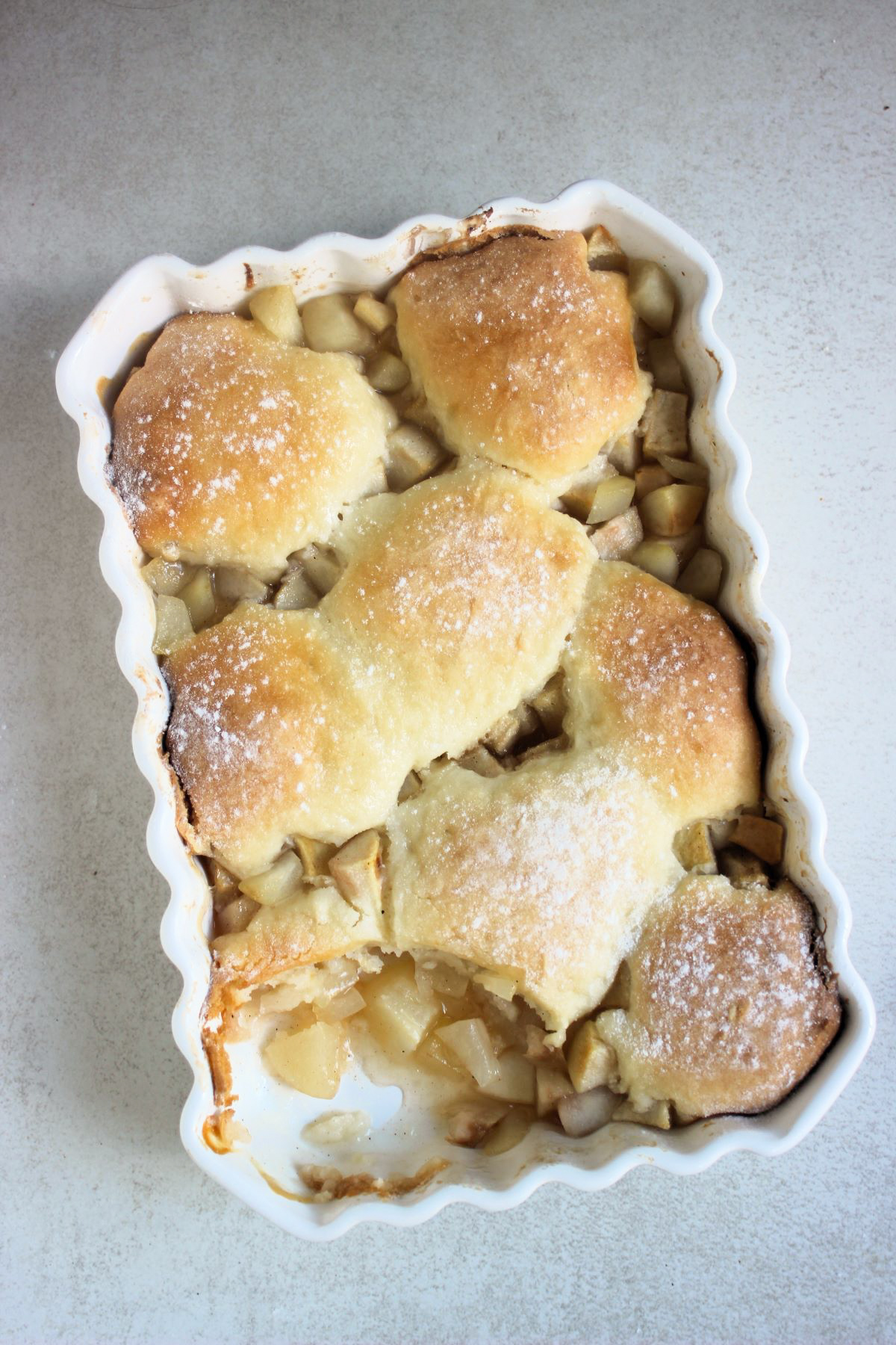 Rectangular white baking dish with pear cobbler without a portion seen from above.