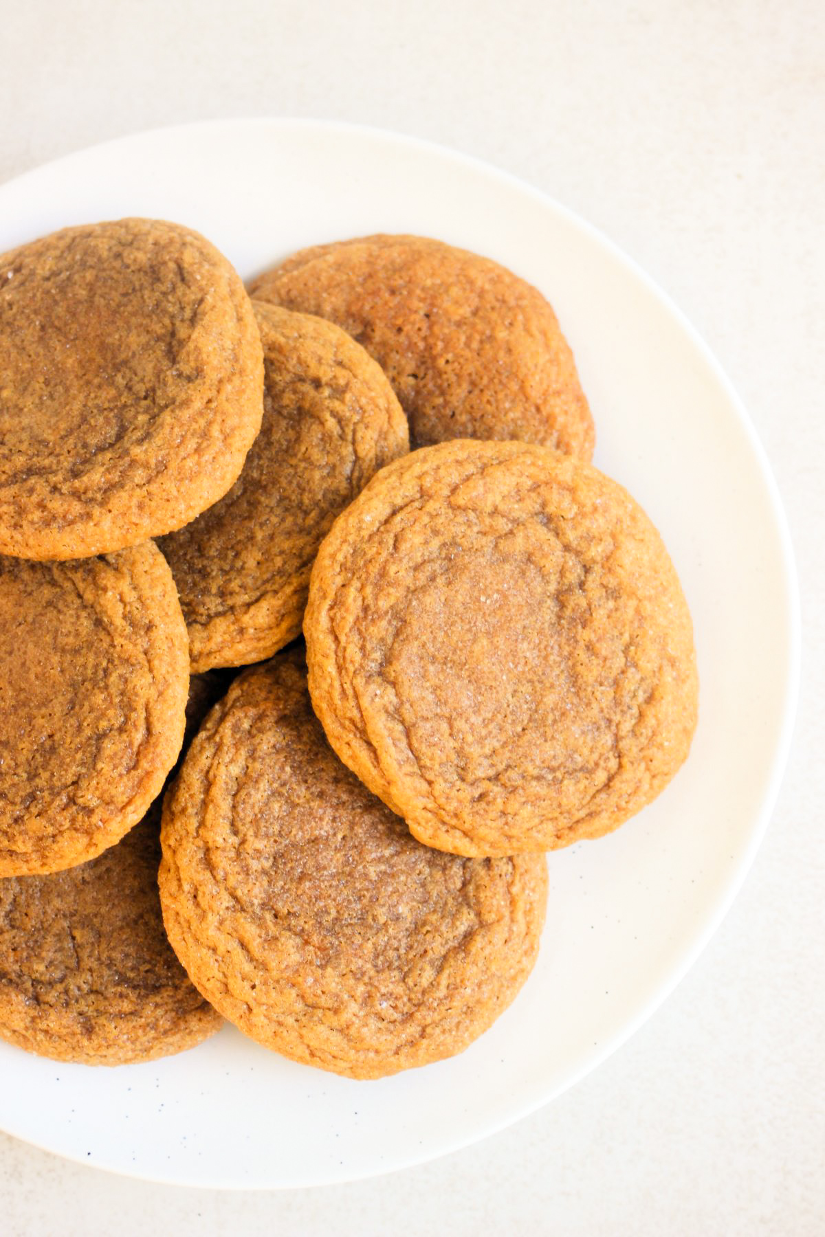 Many ginger molasses cookies on a white plate seen from above.