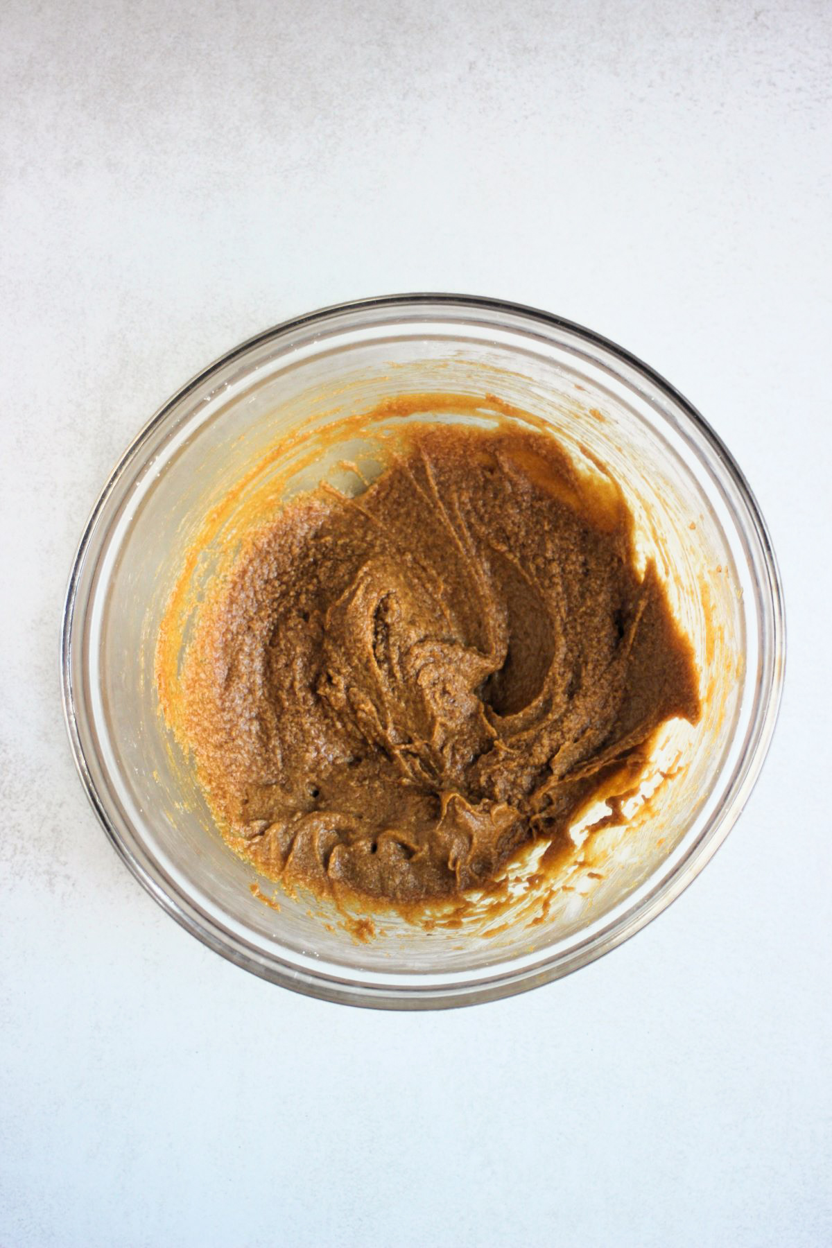 Glass bowl with a sticky brown mixture.