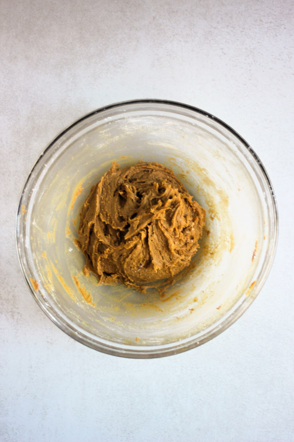 Glass bowl with sticky cookie dough.