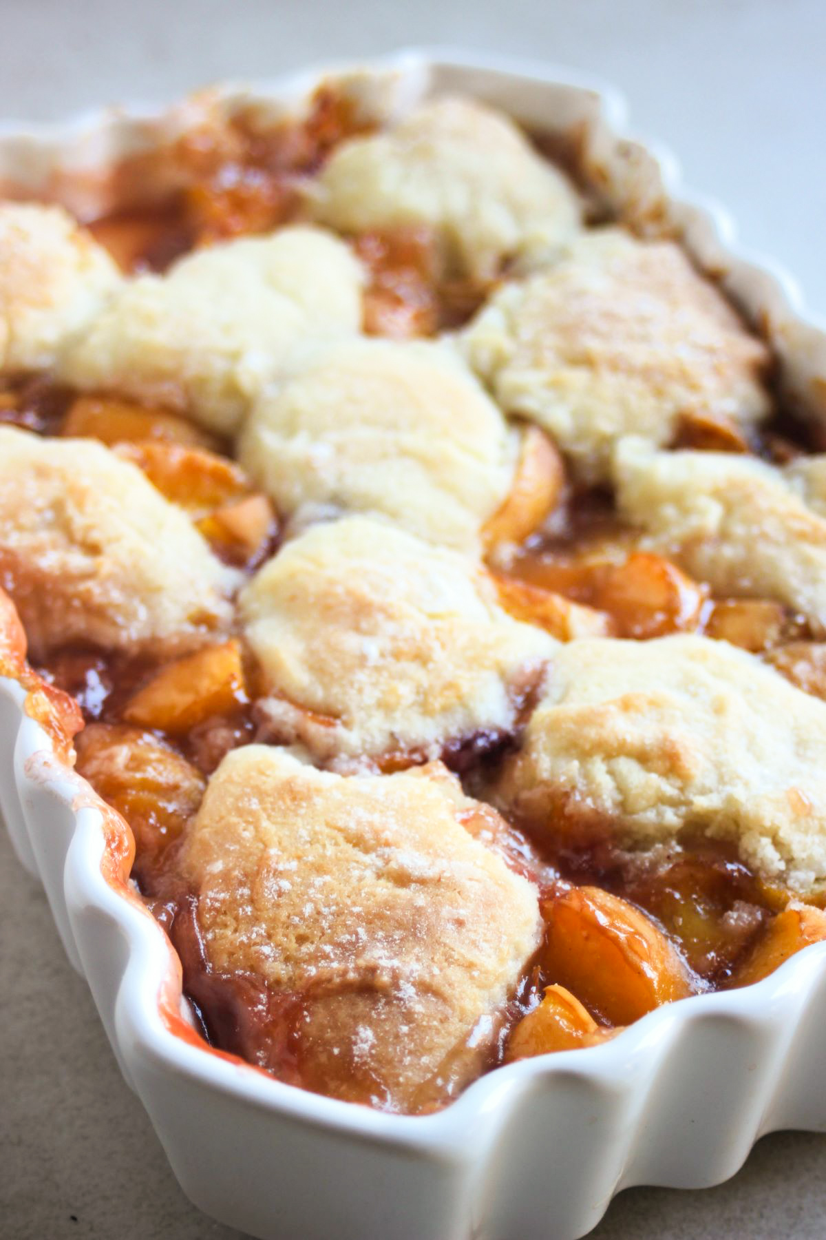 White rectangular baking dish with peach cobbler.