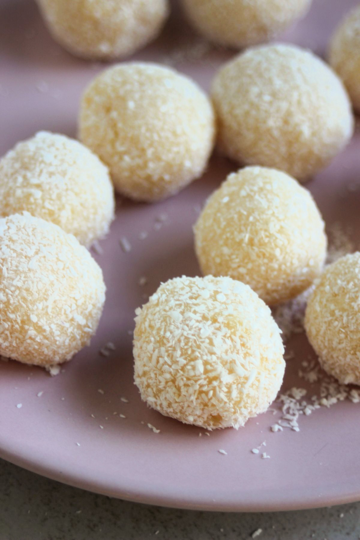 Coconut brigadeiros on a pink plate.