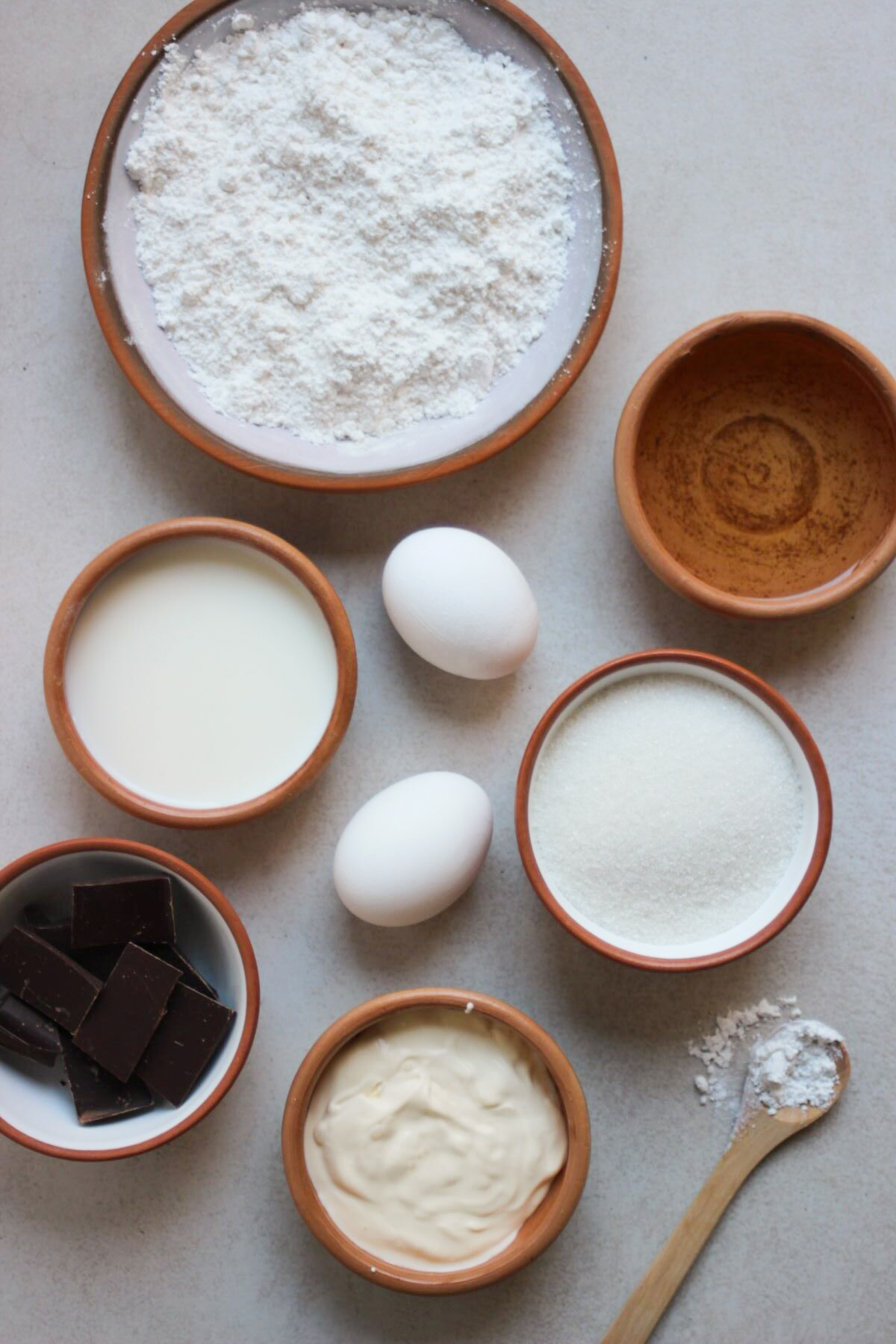 Vanilla cake ingredients on a white surface seen from above.