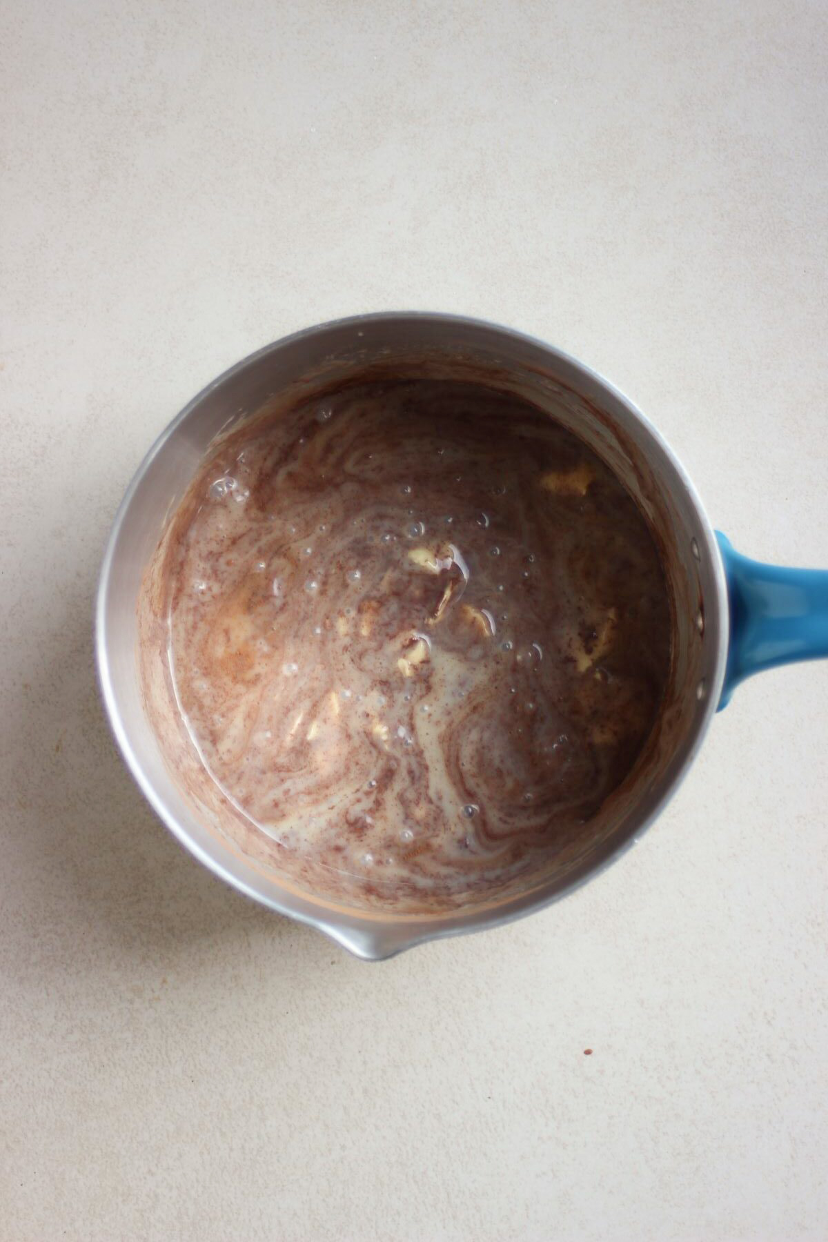 Deep saucepan with a brown mixture.