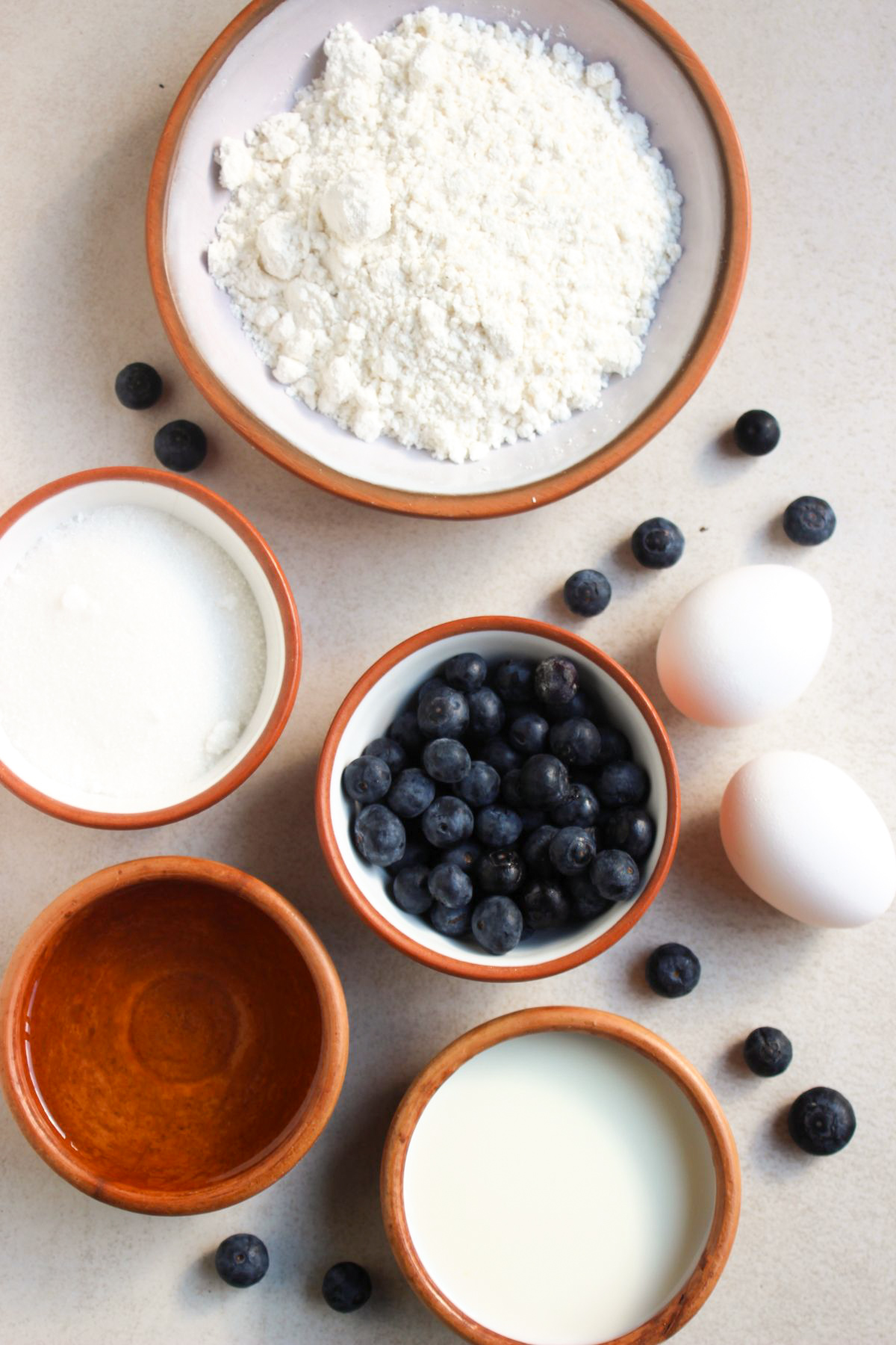 Top view of blueberry streusel muffins ingredients on a white surface.