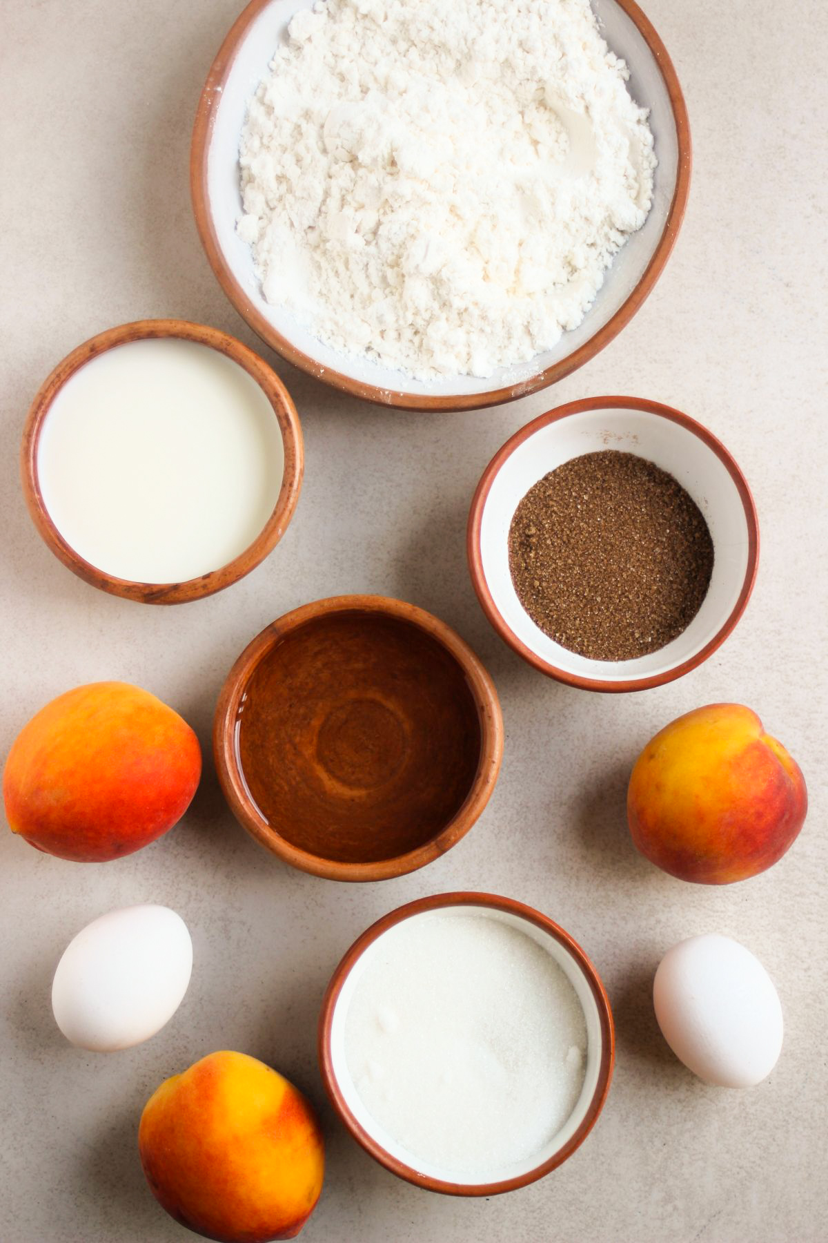 Top view of peach cake ingredients on a white surface.