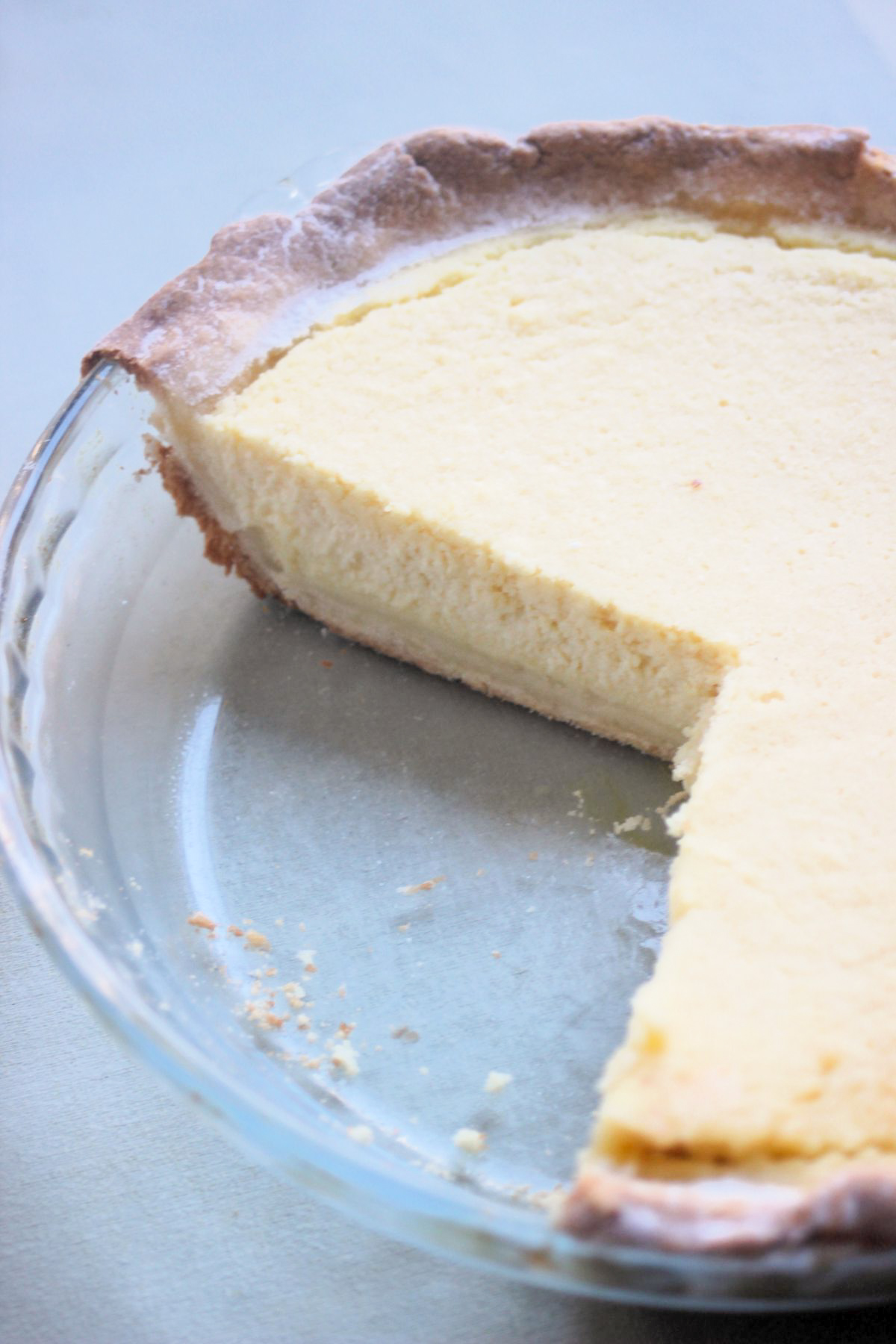 Partial view of a glass baking dish with half of a ricotta pie.