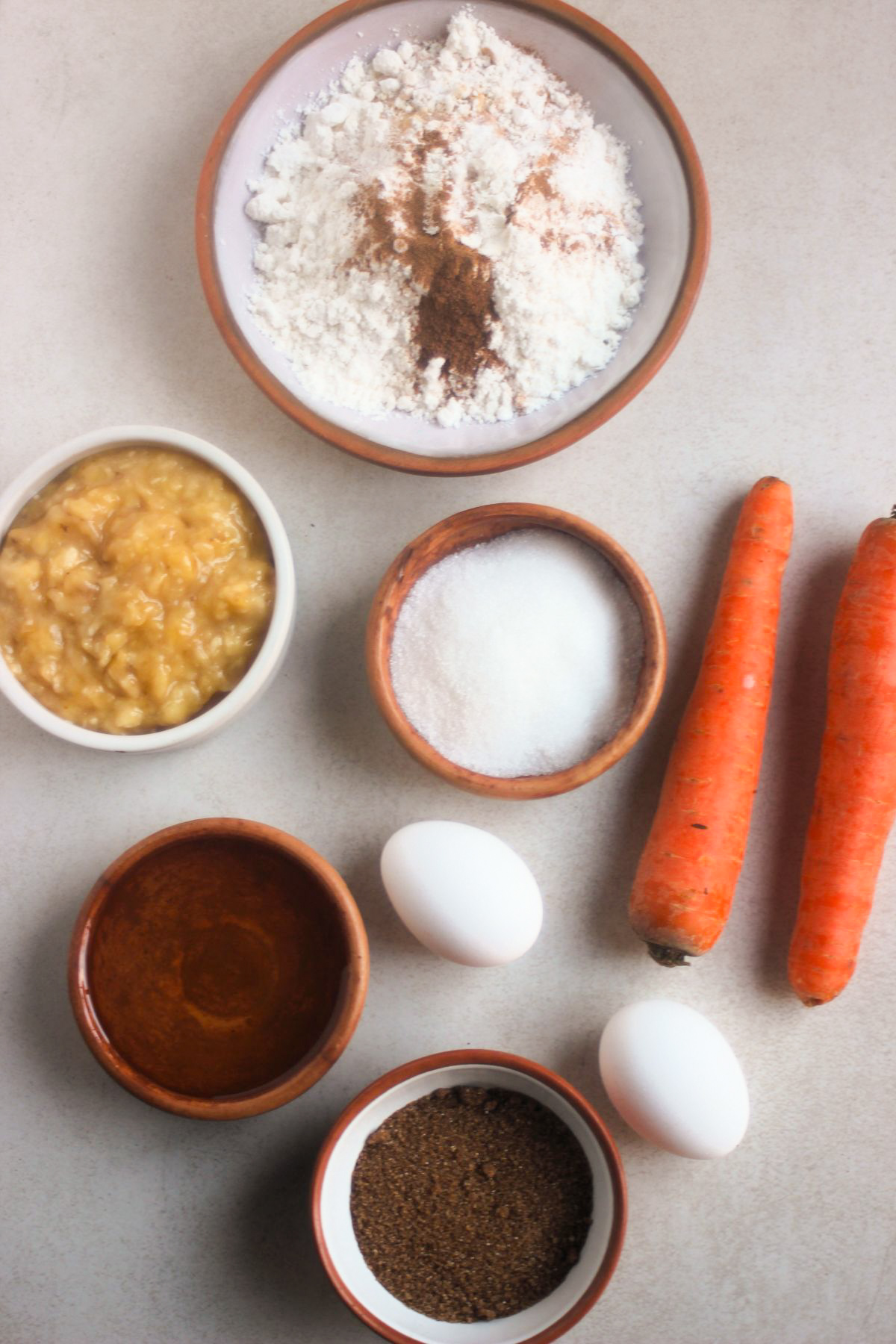 Top view of carrot banana bread ingredients on a white surface.