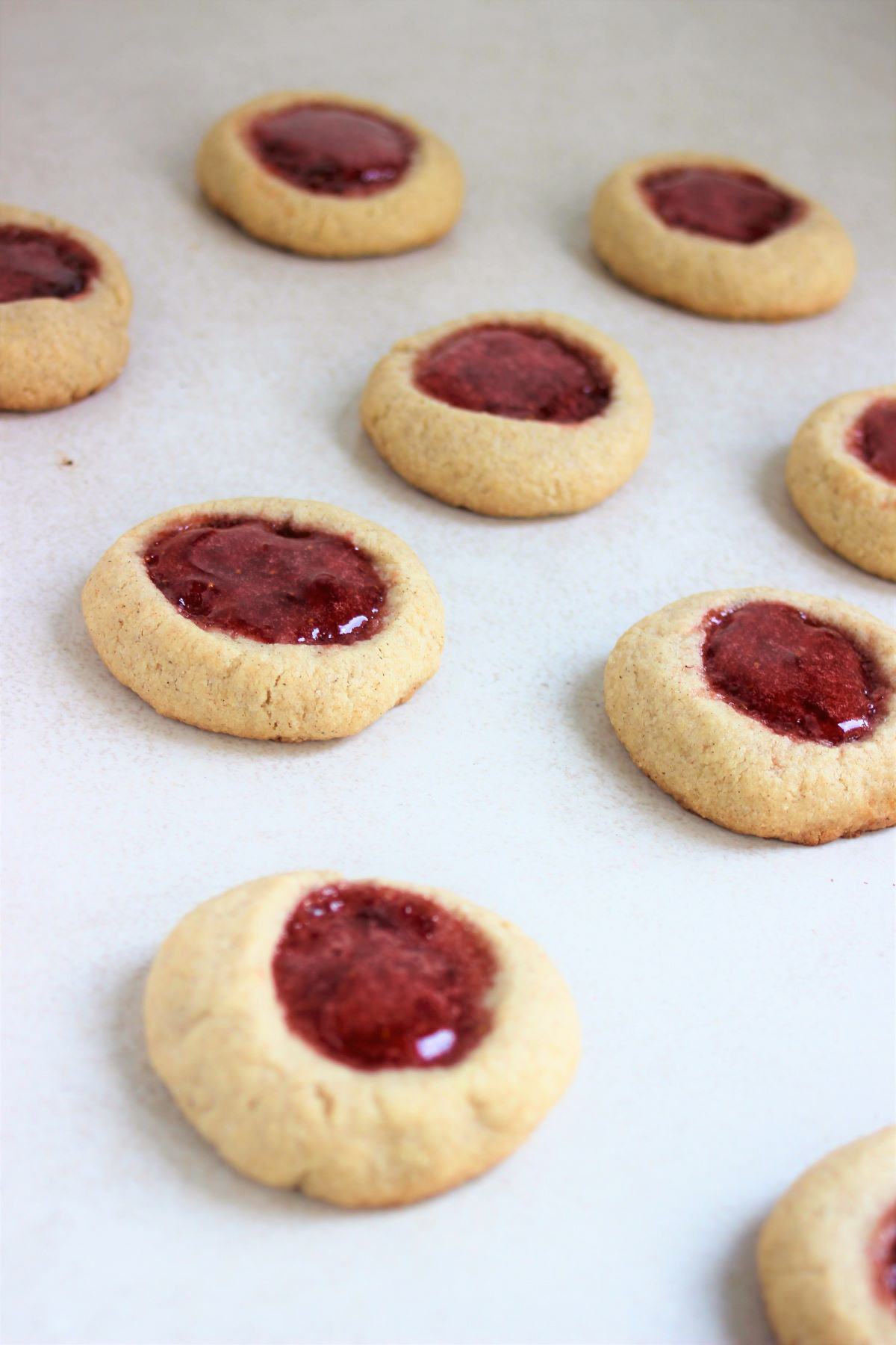 Almond thumbprints cookies on a white surface.