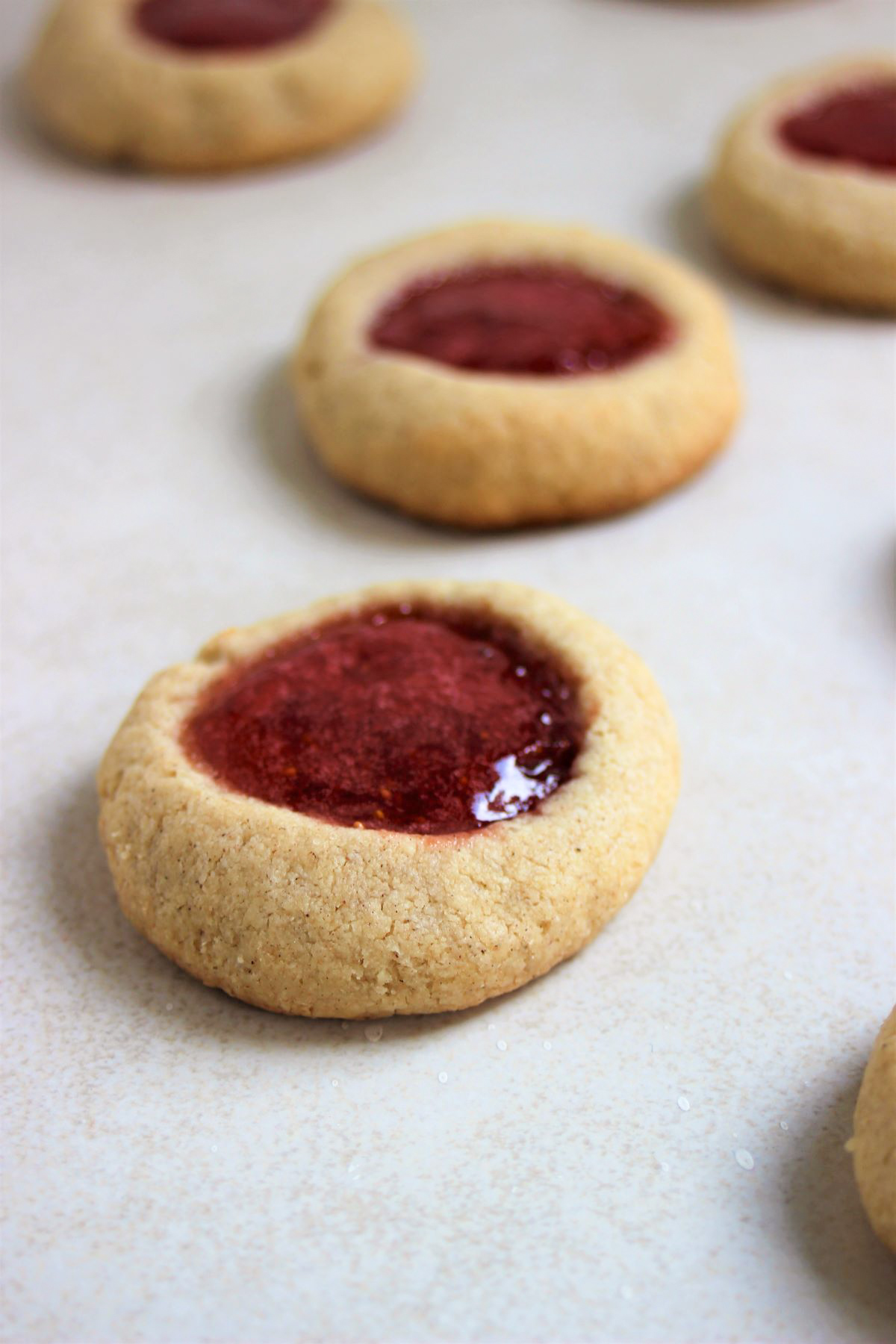 Almond thumbprints cookies on a white surface.