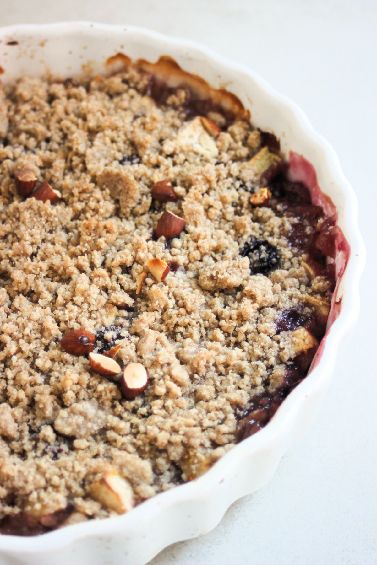 Apple crumble in a round white baking dish.