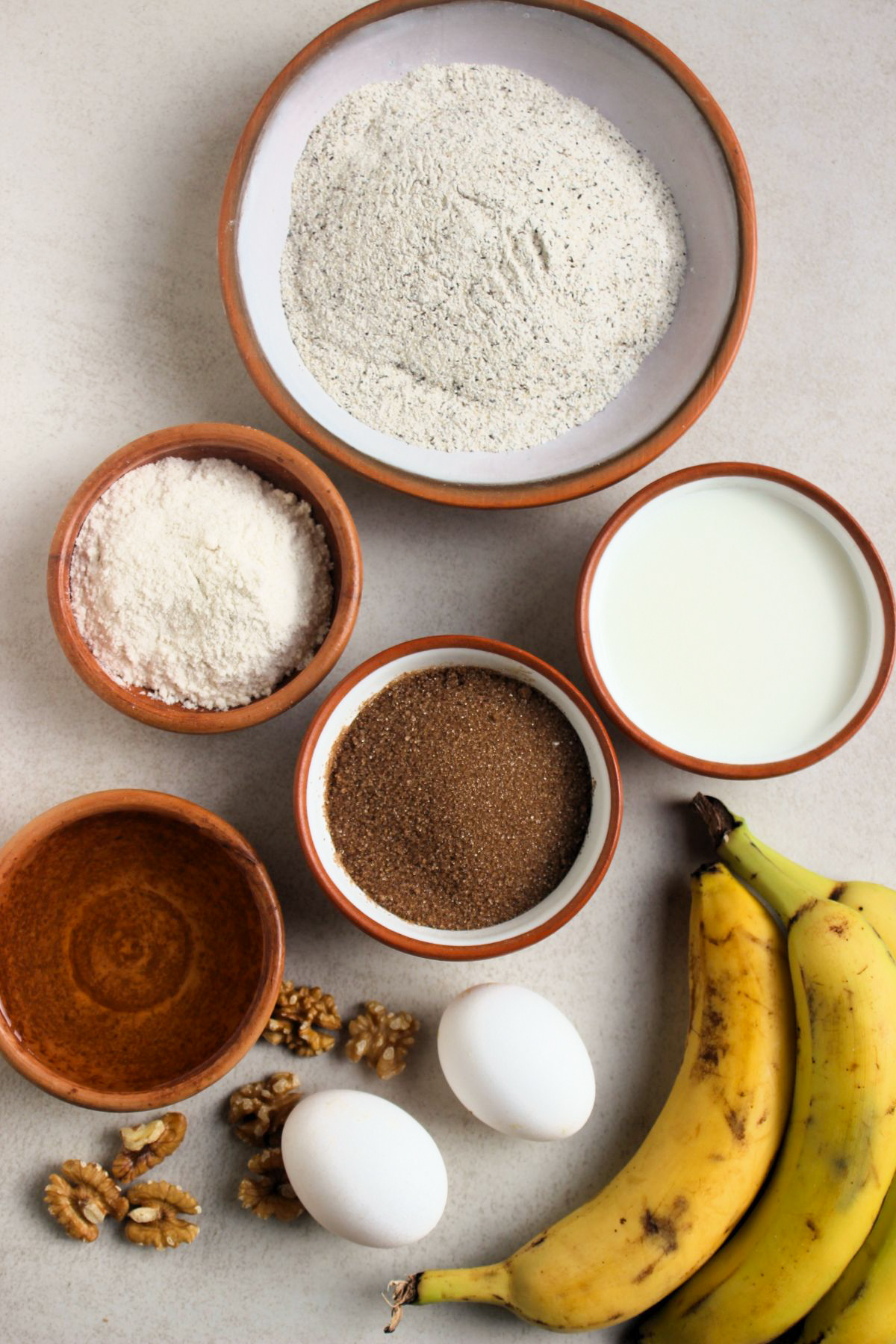 Banana buckwheat bread ingredients on a white surface seen from above.