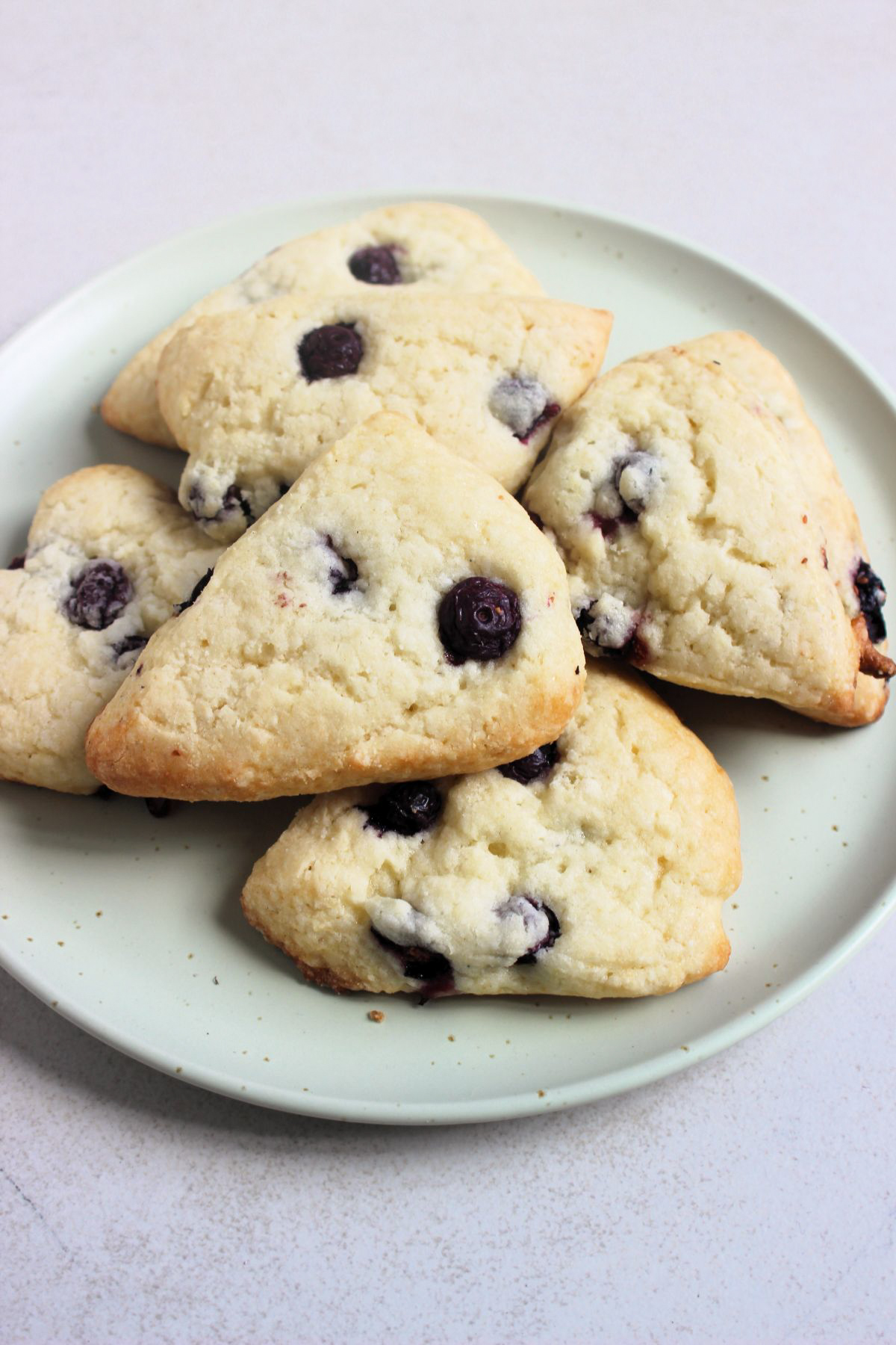 Blueberry scones on an aqua-green plate.