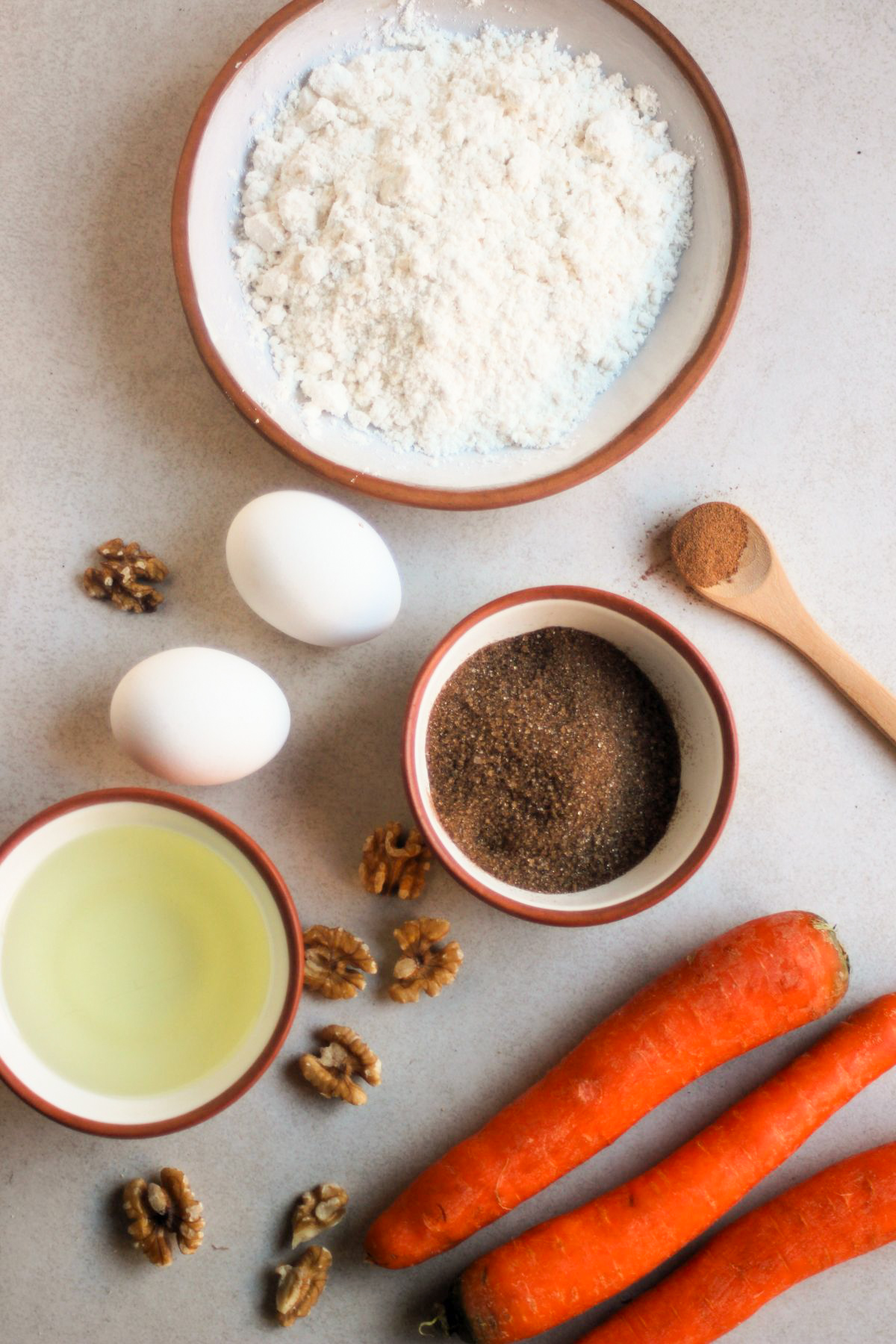 Carrot cake muffins ingredients on a white surface seen from above.