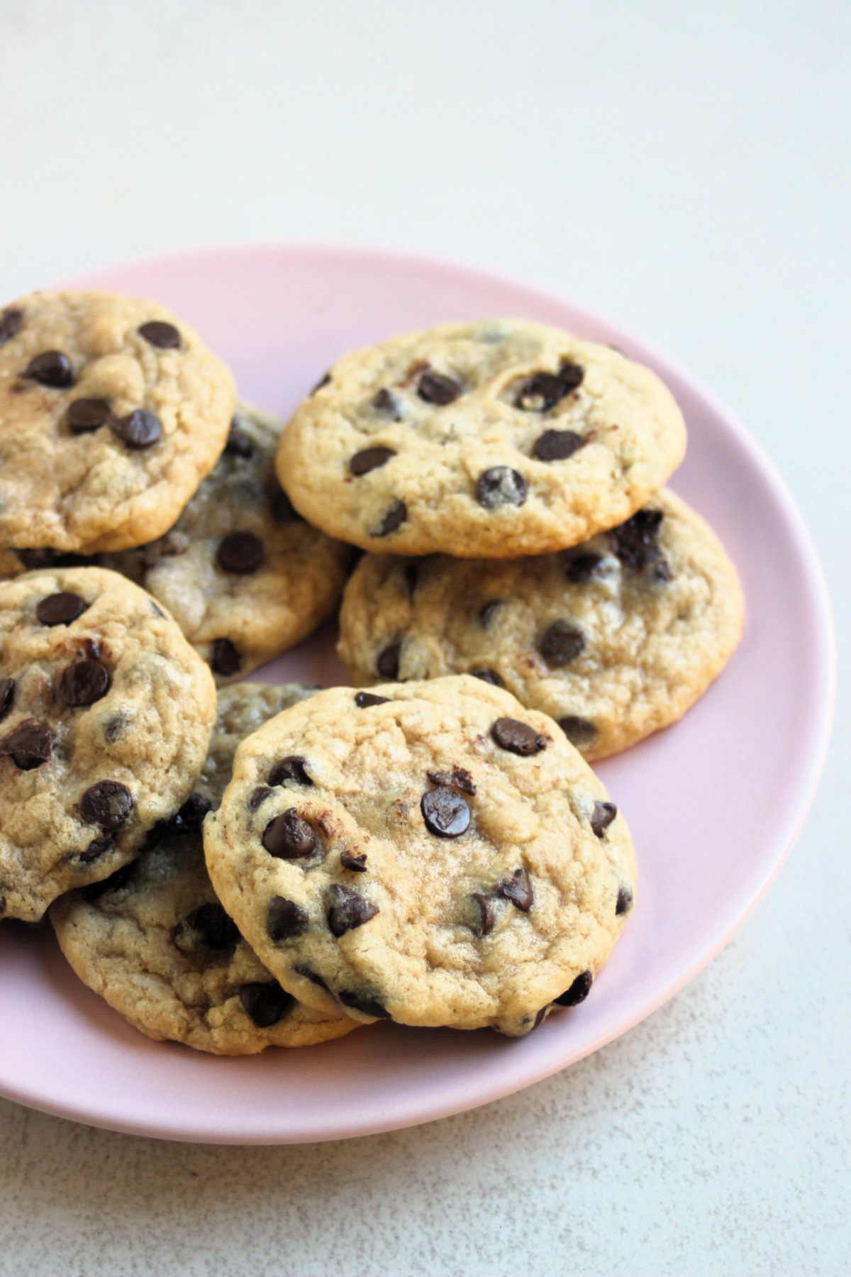 Chocolate chip cookies on a pink plate.