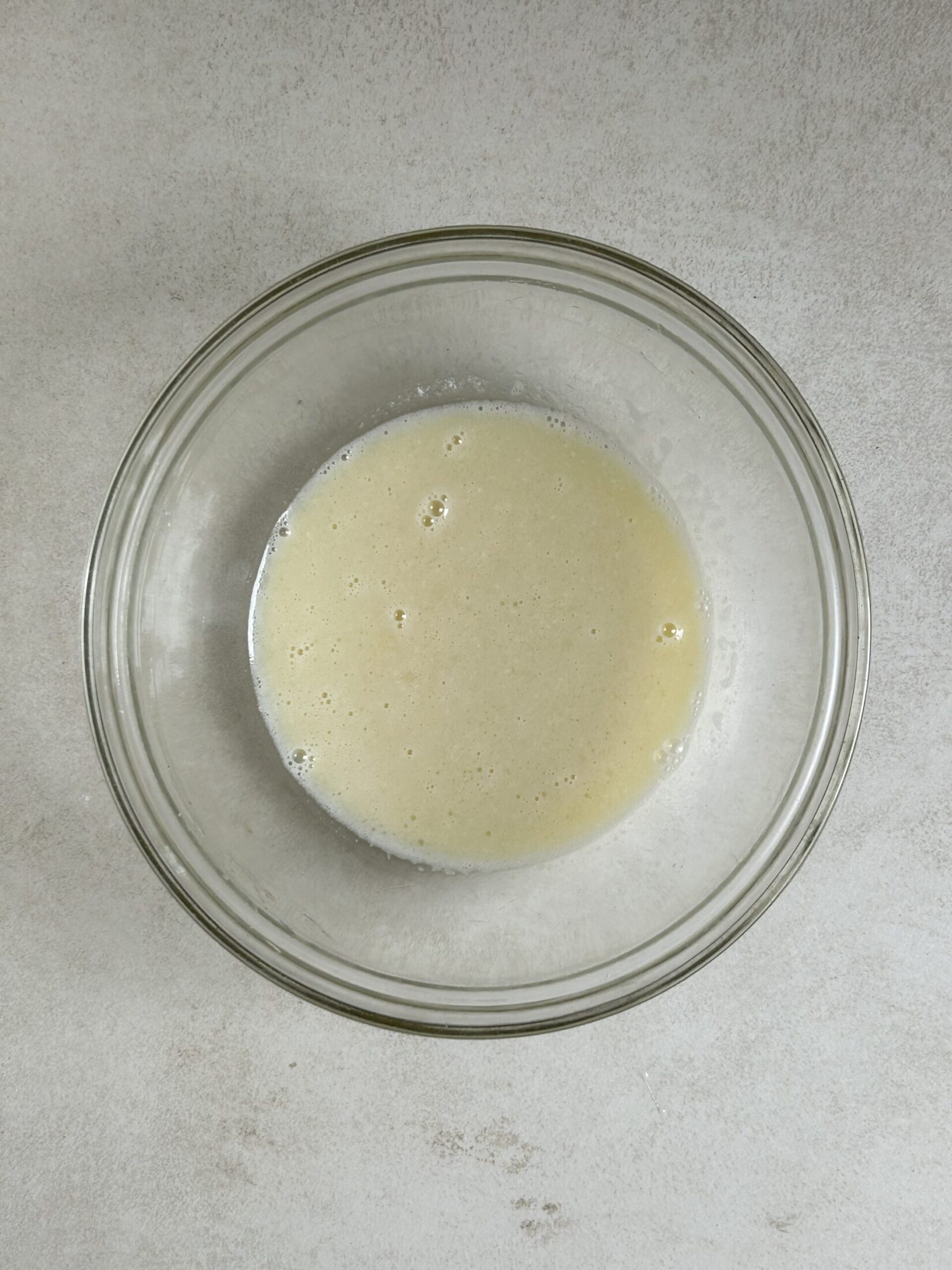 Glass bowl with a cream colour liquid seen from above.