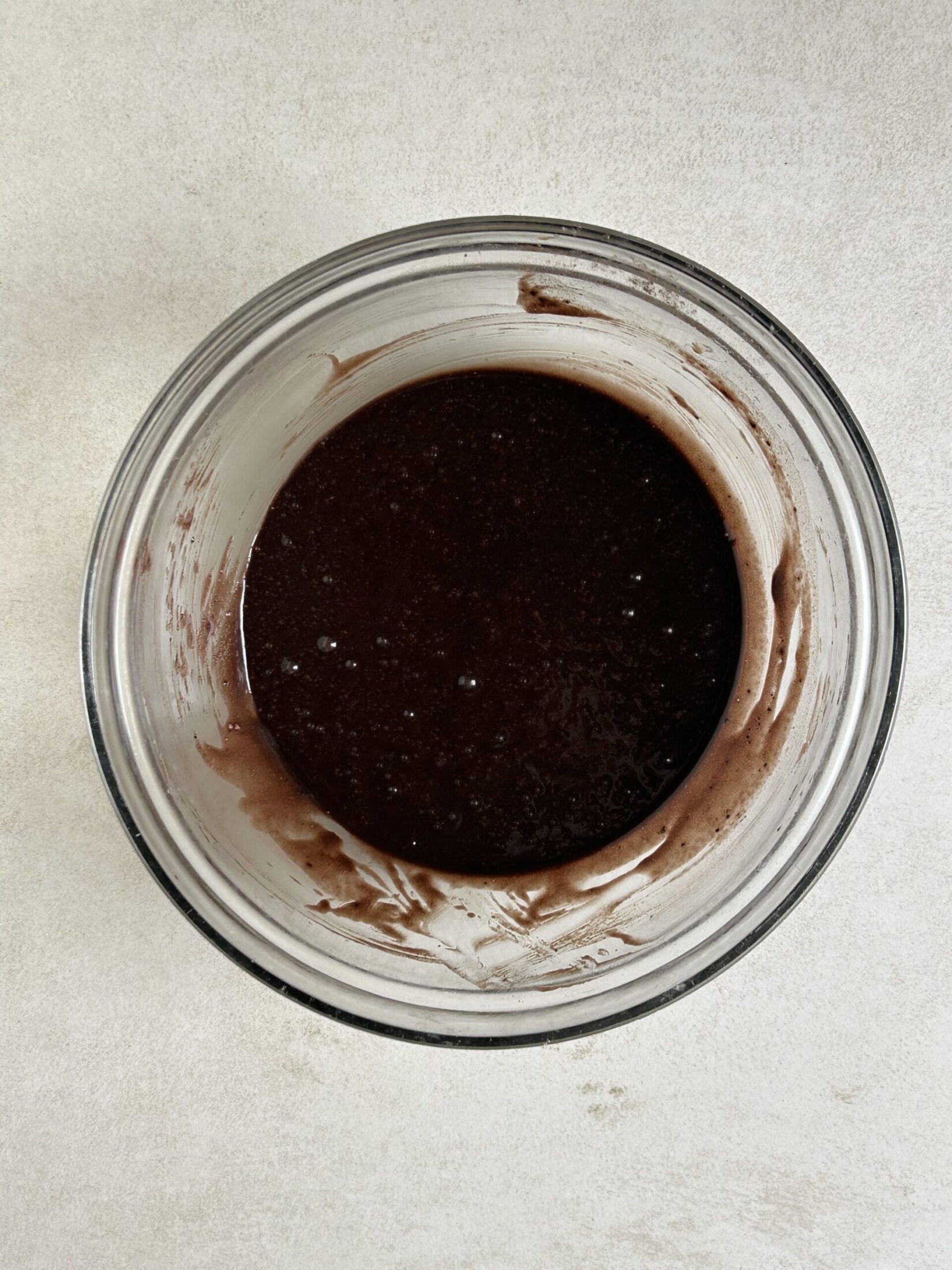Glass bowl with a brown mixture seen from above.