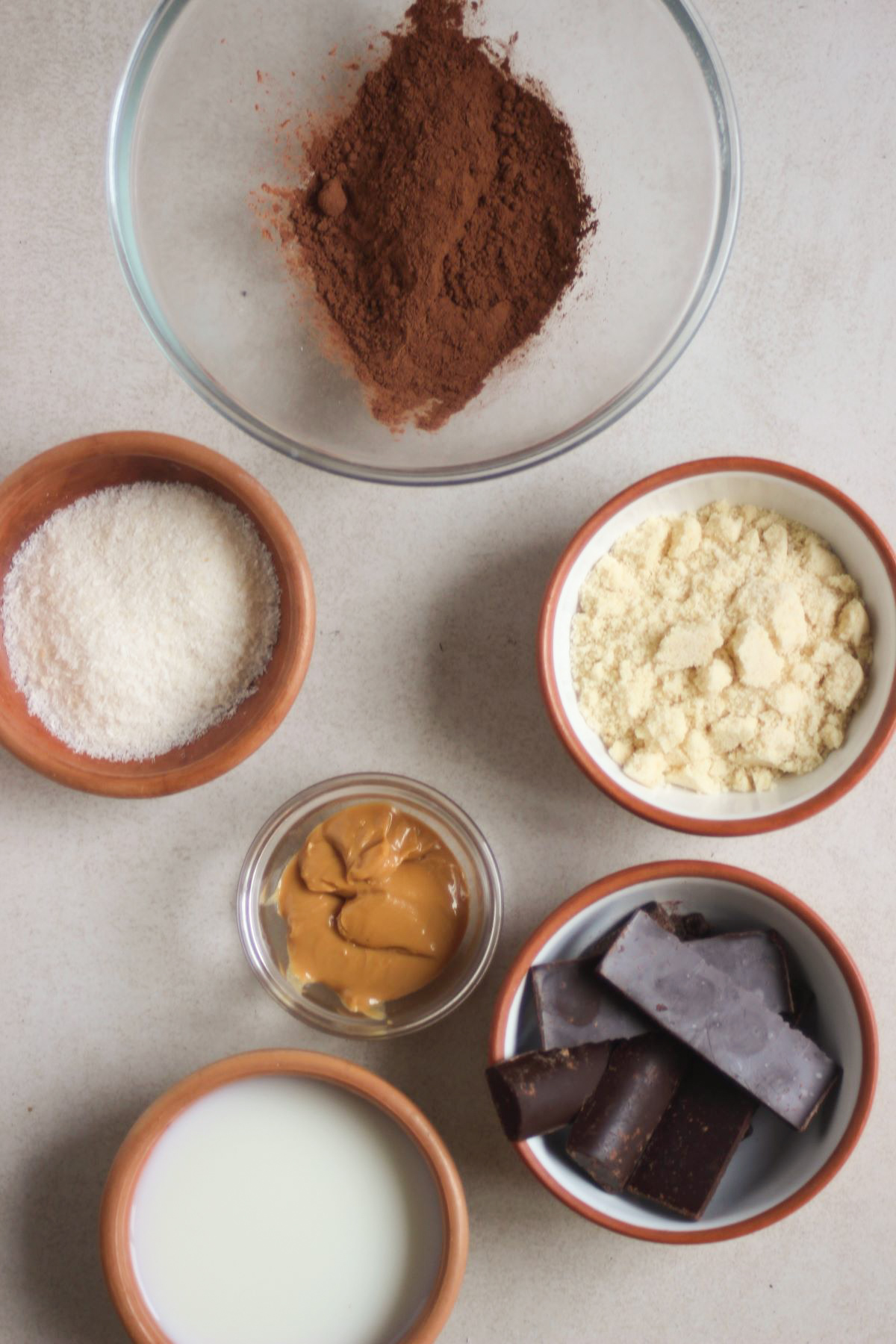 Chocolate peanut butter balls ingredients on a white surface seen from above.