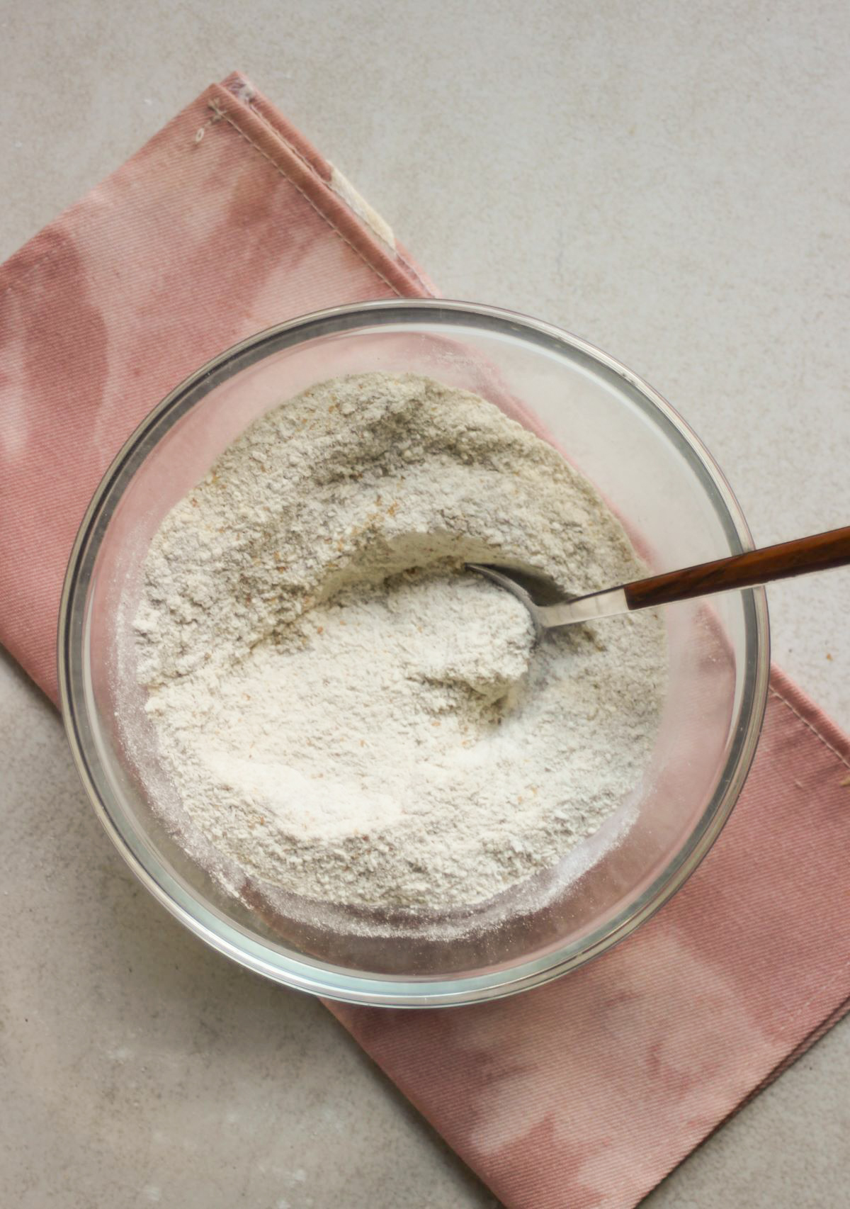 Glass bowl with a mix of flours and a pink napkin under the bowl.