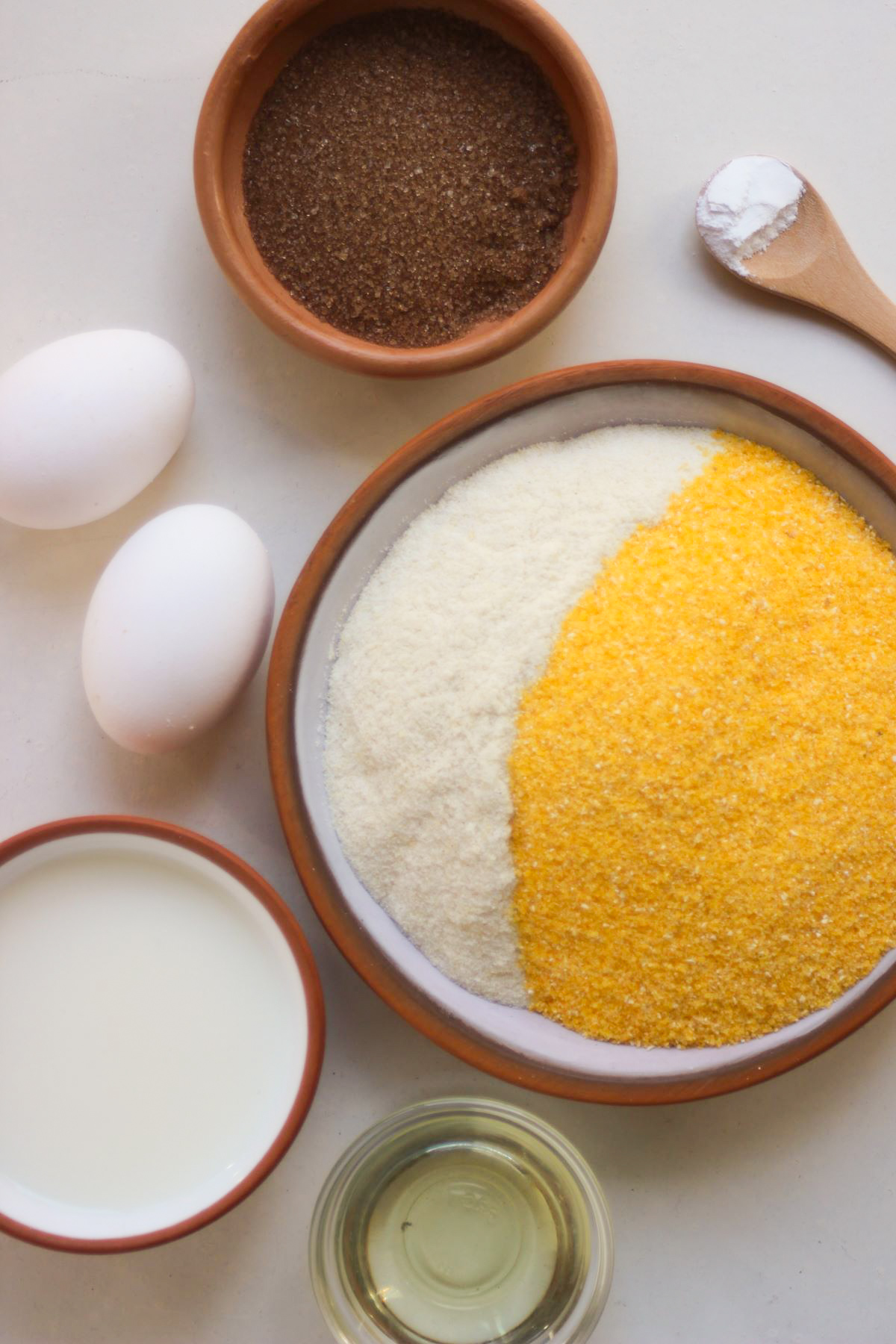 Cornbread ingredients on a white surface seen from above.