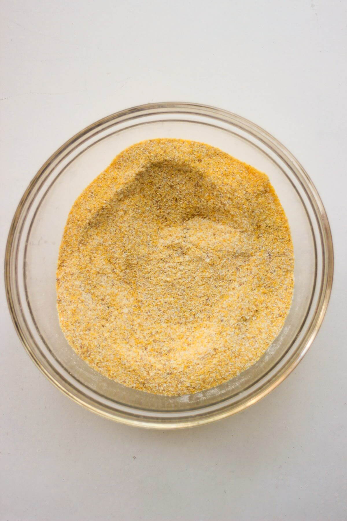 Glass bowl with a mix of flours that includes corn flour.