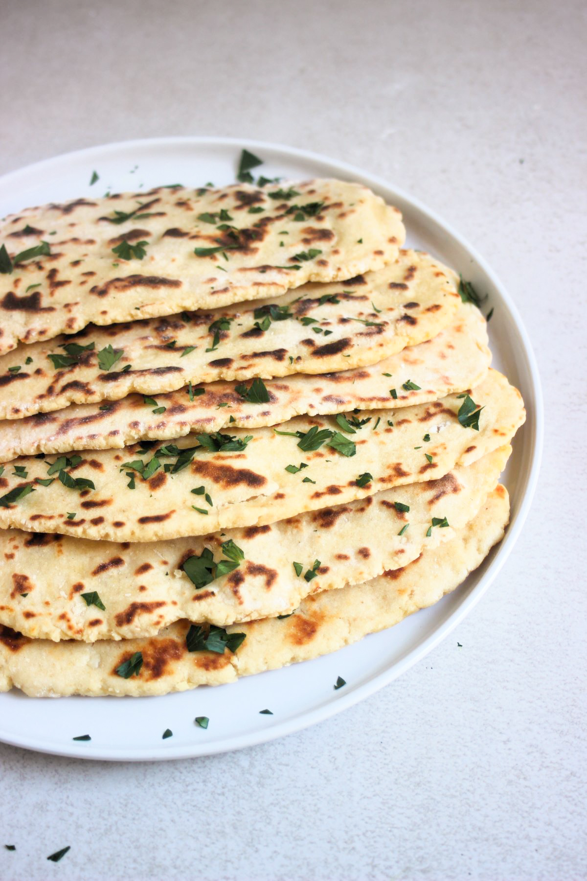 Flatbread plate with chopped fresh parsley on a white plate.