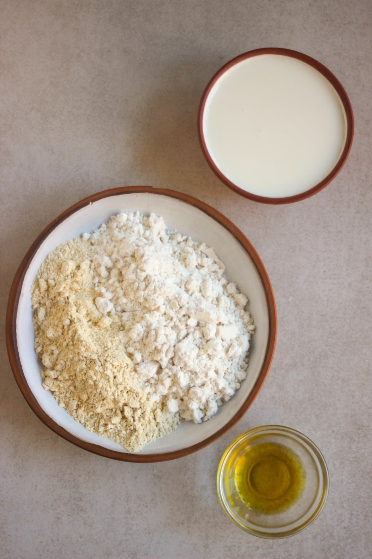 Flatbread ingredients on a white surface seen from above.