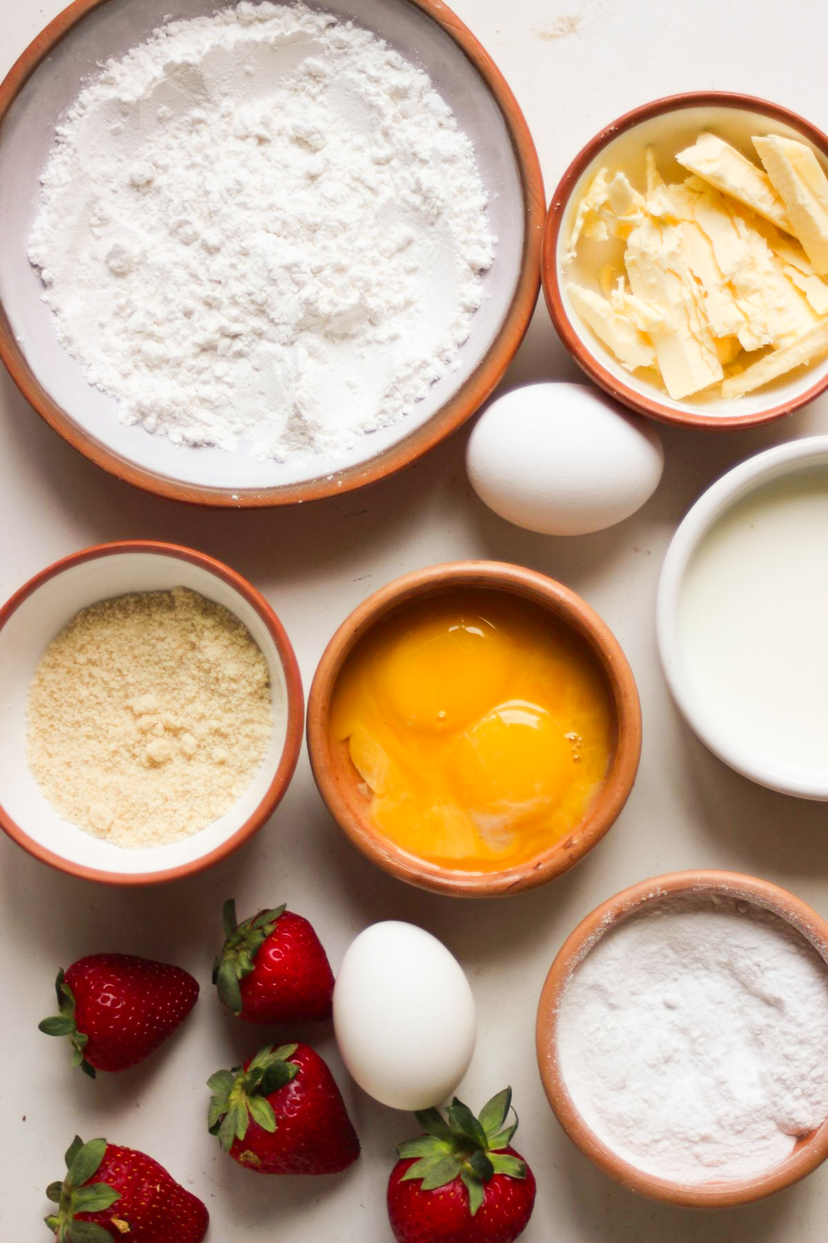 Fruit tartlets ingredients on a white surface seen from above.