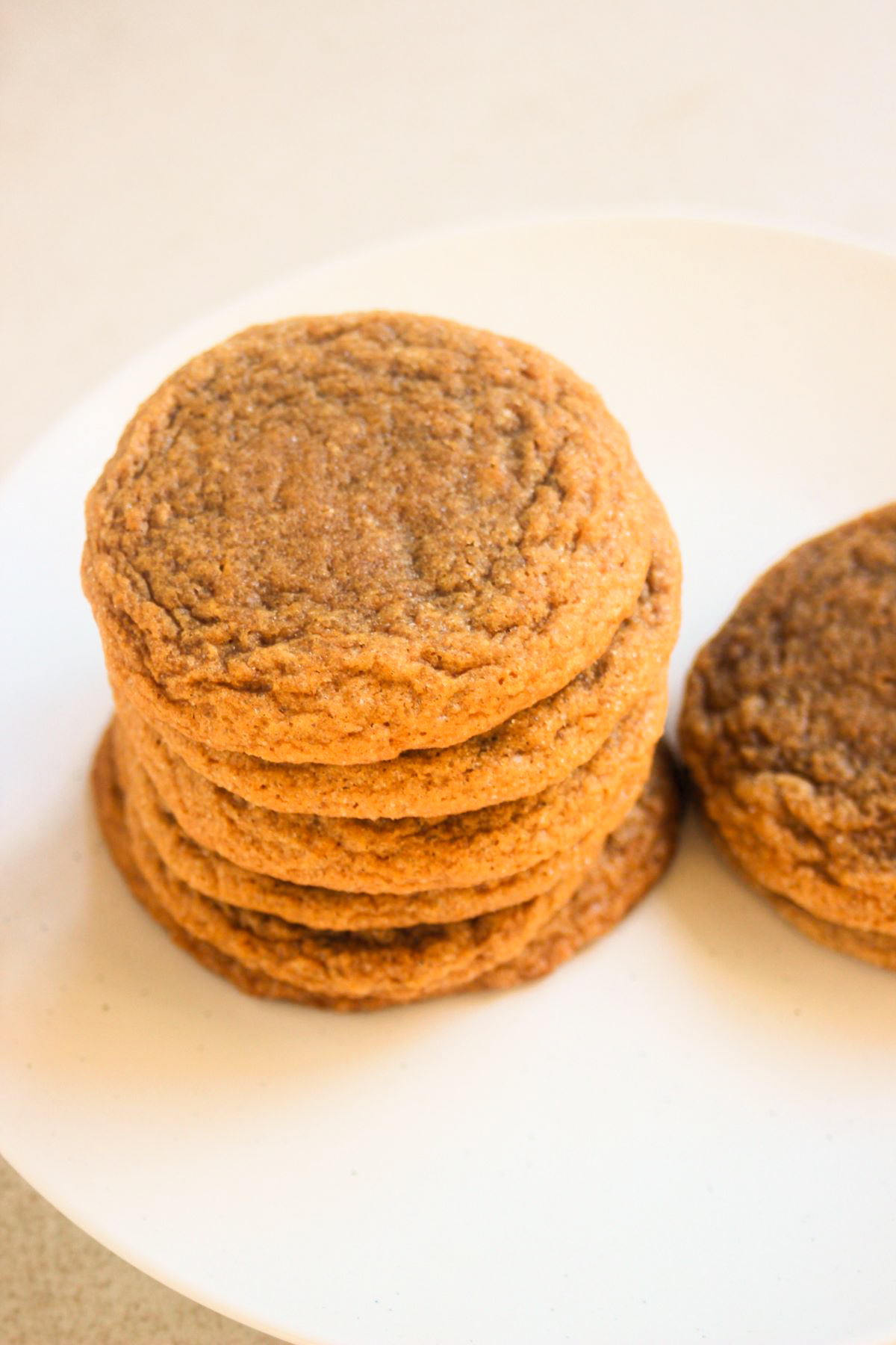 Stack of ginger molasses cookies on a white plate.