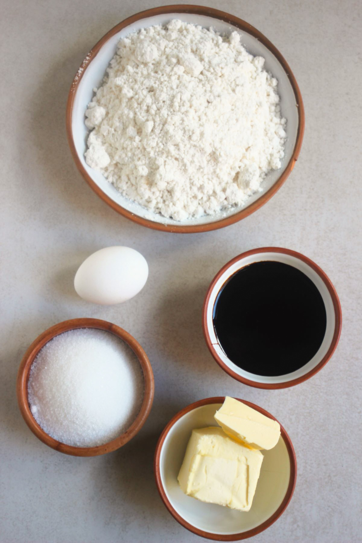Ginger molasses cookies ingredients on a white surface seen from above.